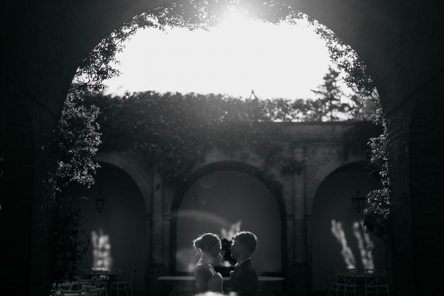 Dramatic backlit evening shot through stone archways.