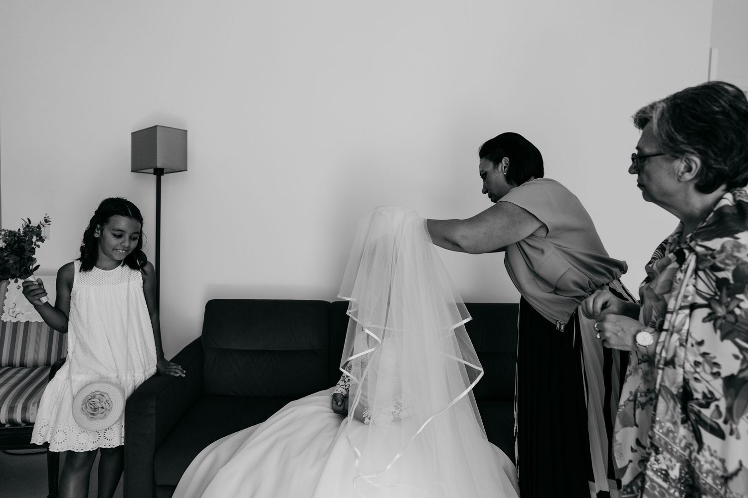 Wedding party members prepare in a light-filled room with modern furnishings.