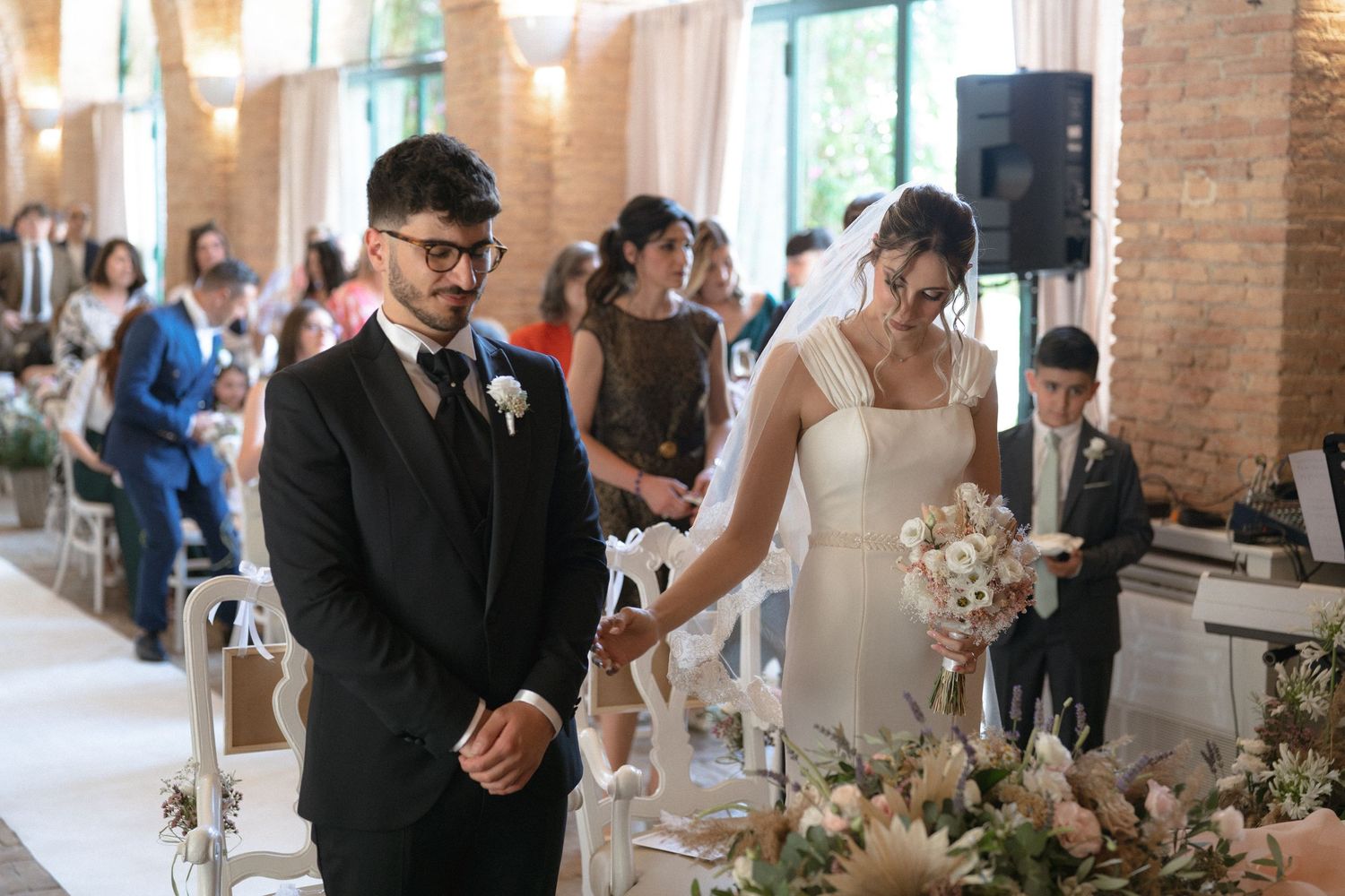Wedding reception in a rustic brick venue with floral decorations.