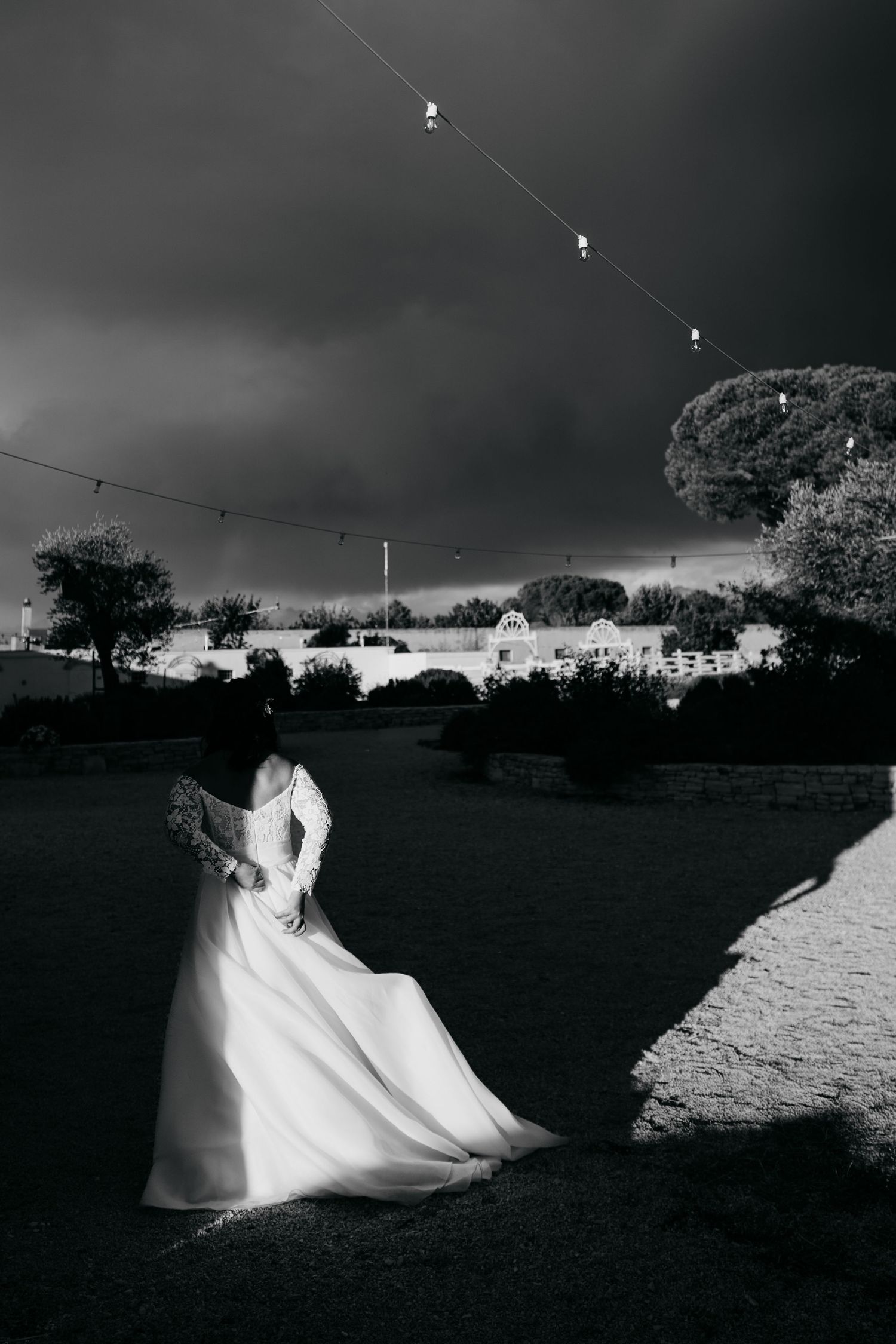 Dramatic black and white photos of a flowing white wedding dress in motion against a dark sky.