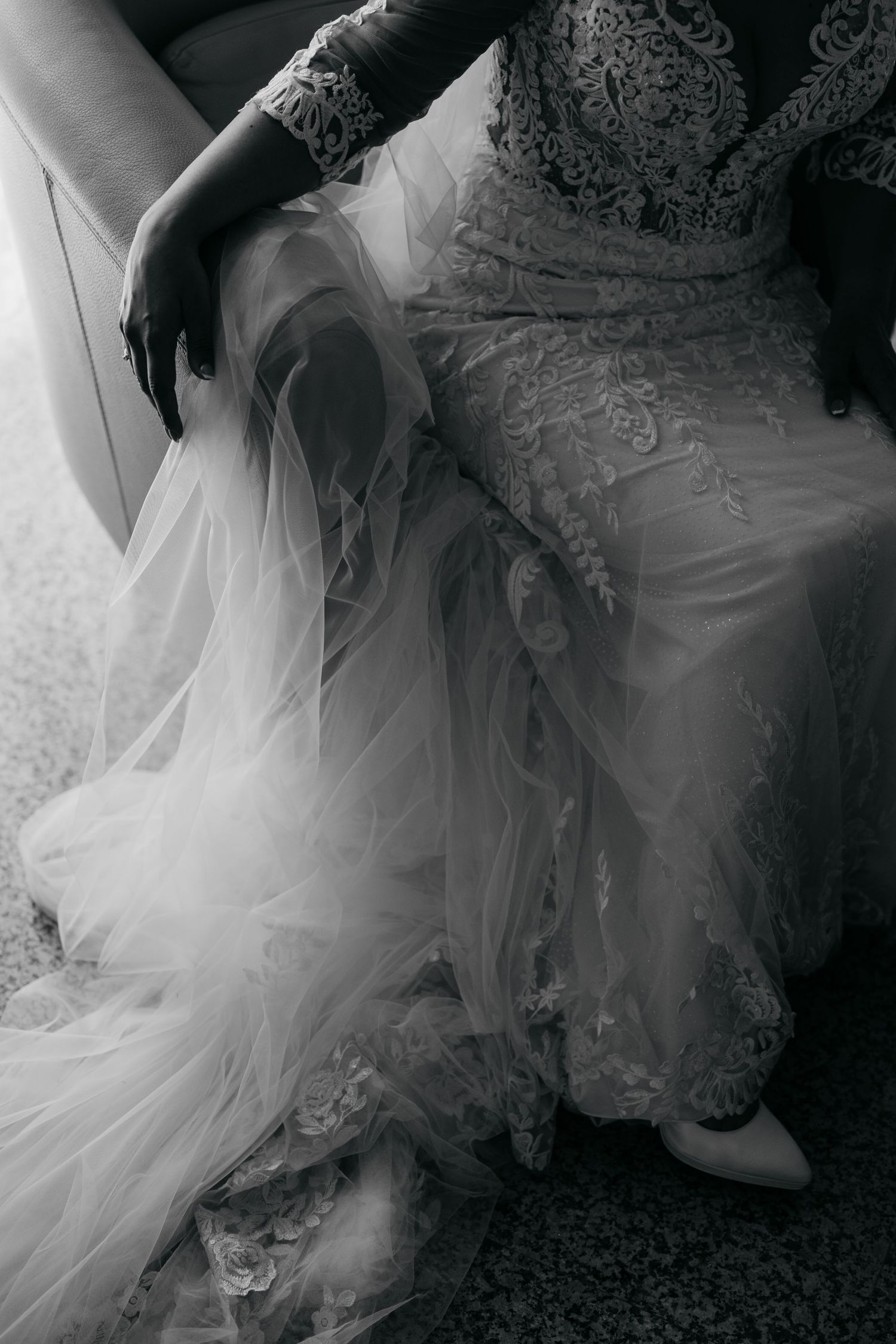 Artistic black and white detail shots of a flowing tulle wedding gown with lace embellishments.