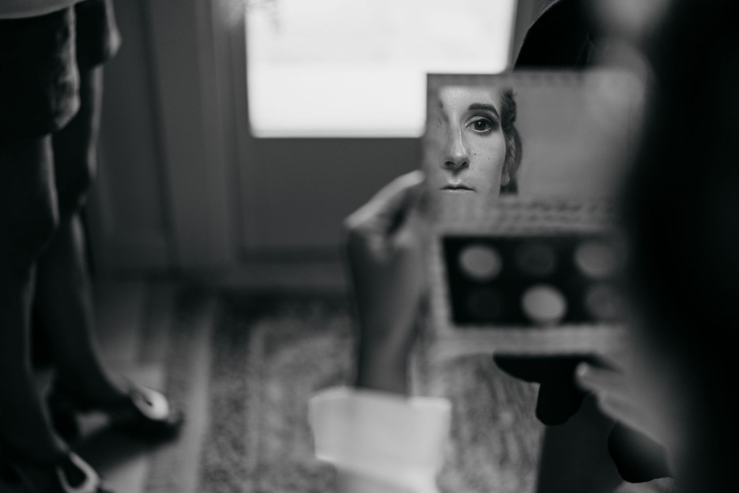 A creative black and white photograph showing a reflection in a handheld mirror.