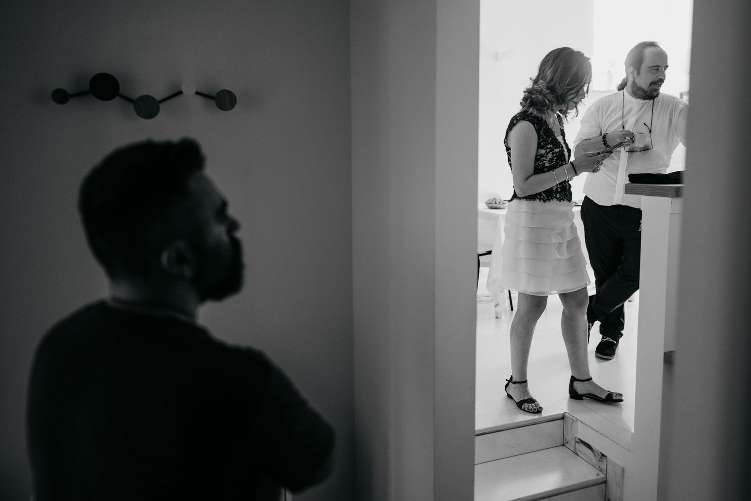 Black and white image showing silhouettes of people in a doorway.