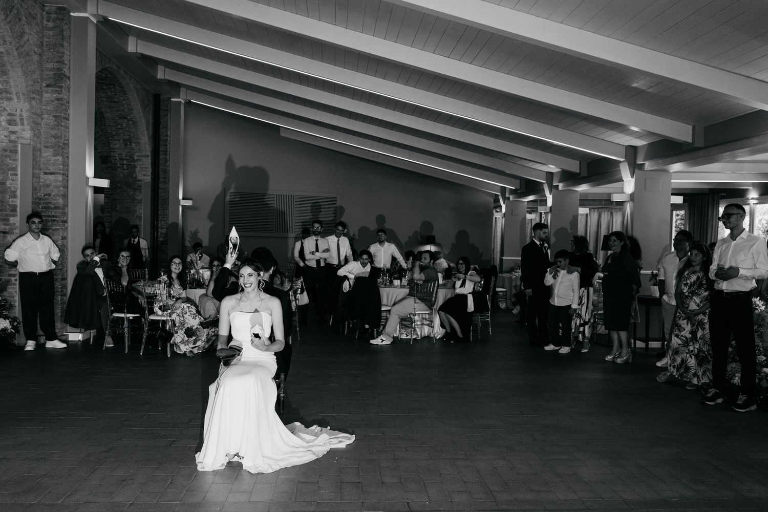 Black and white photo of a wedding reception dance floor with guests.