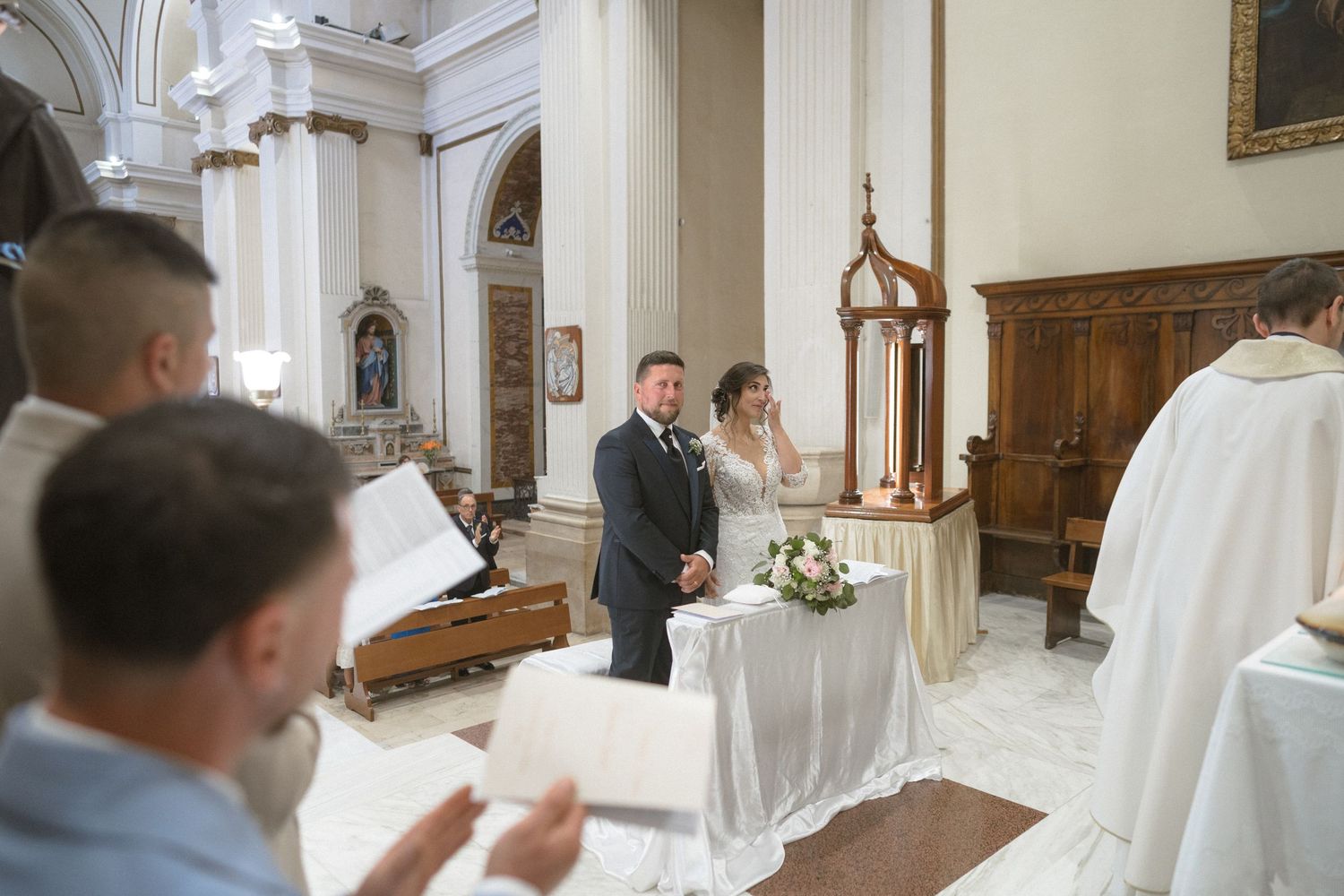 Elegant church wedding ceremony with white decor and classic architectural details.