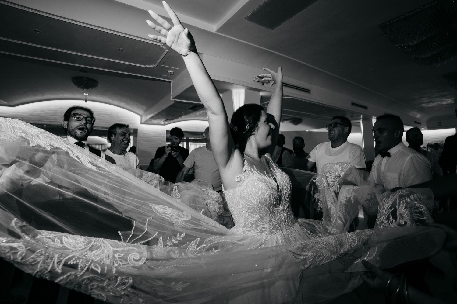 A black and white photo of dancing and celebration at a wedding reception.