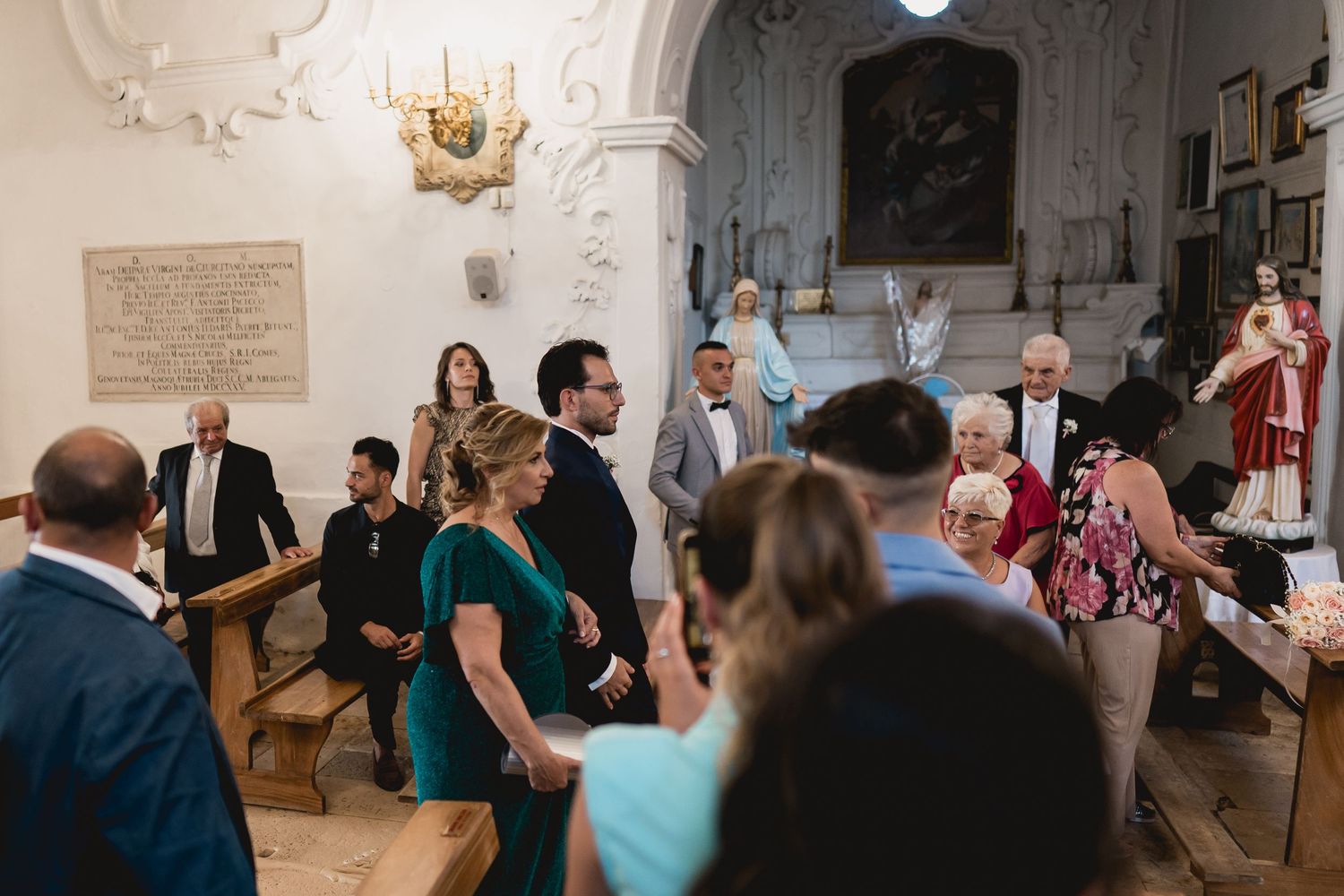 Wedding guests gathered inside an ornate church with traditional architecture.