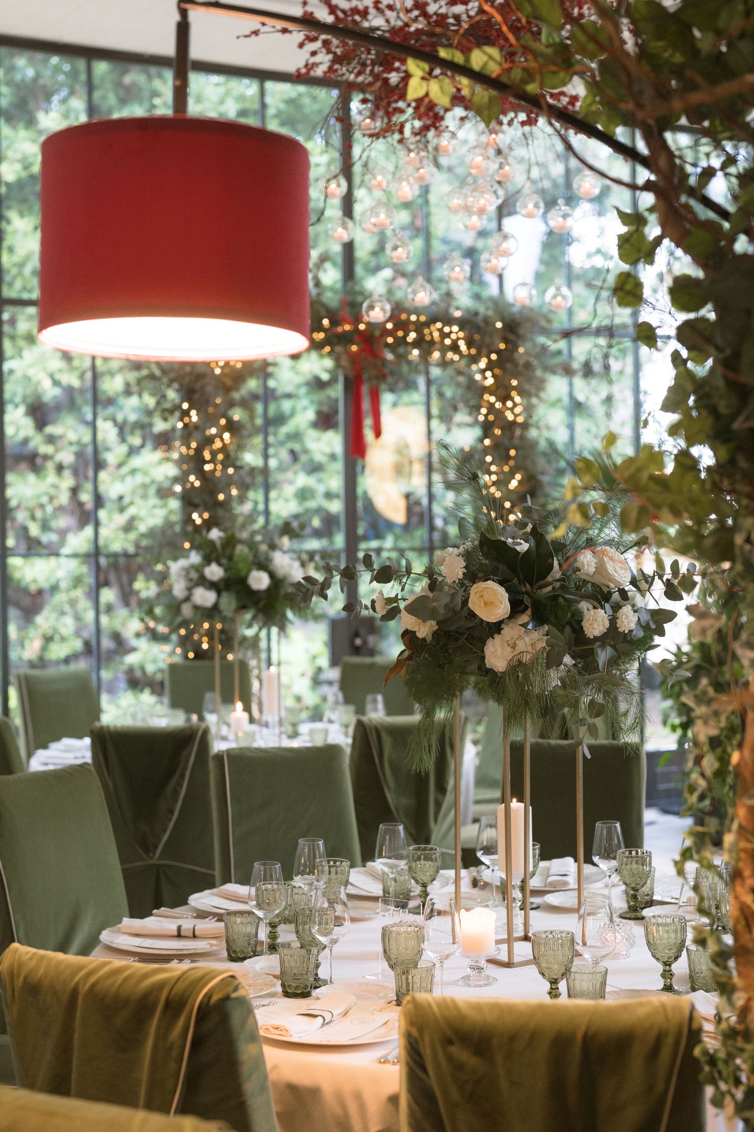 Elegant wedding reception table with green velvet chairs and floral centerpiece.