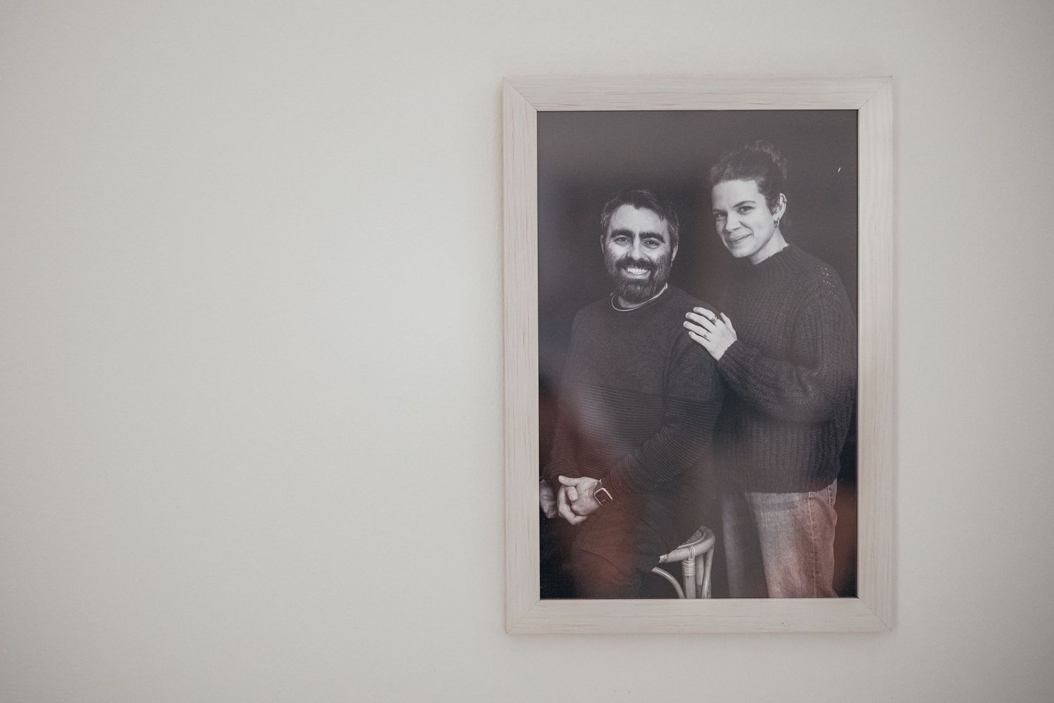 A black and white photograph in a white frame displayed on a wall.
