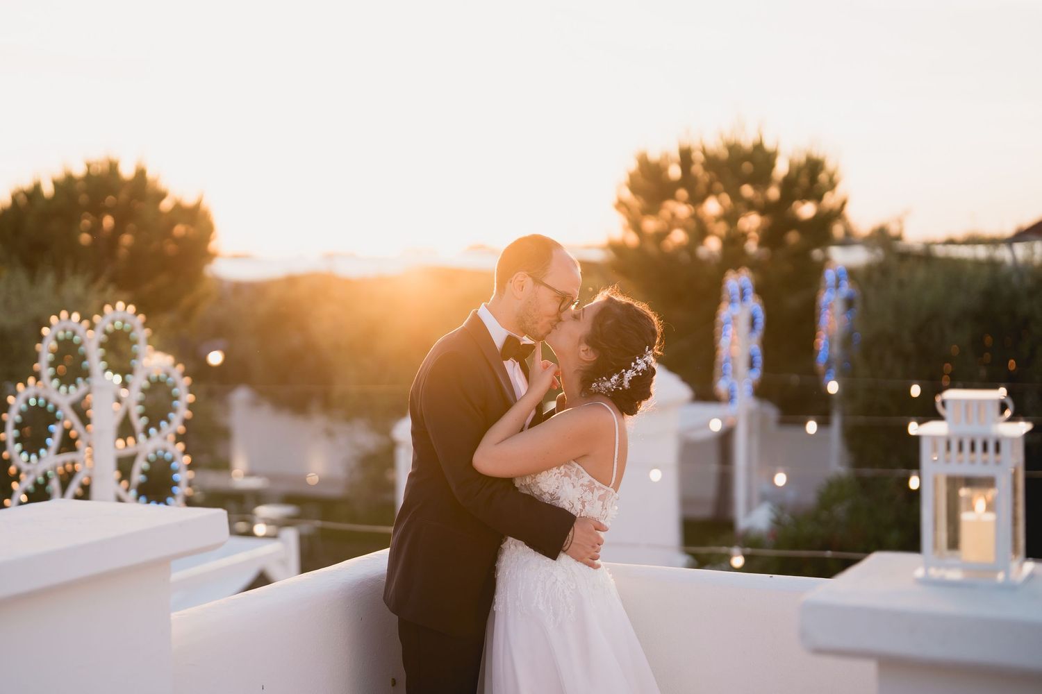 Intimate sunset wedding portrait with golden light and white architectural details.