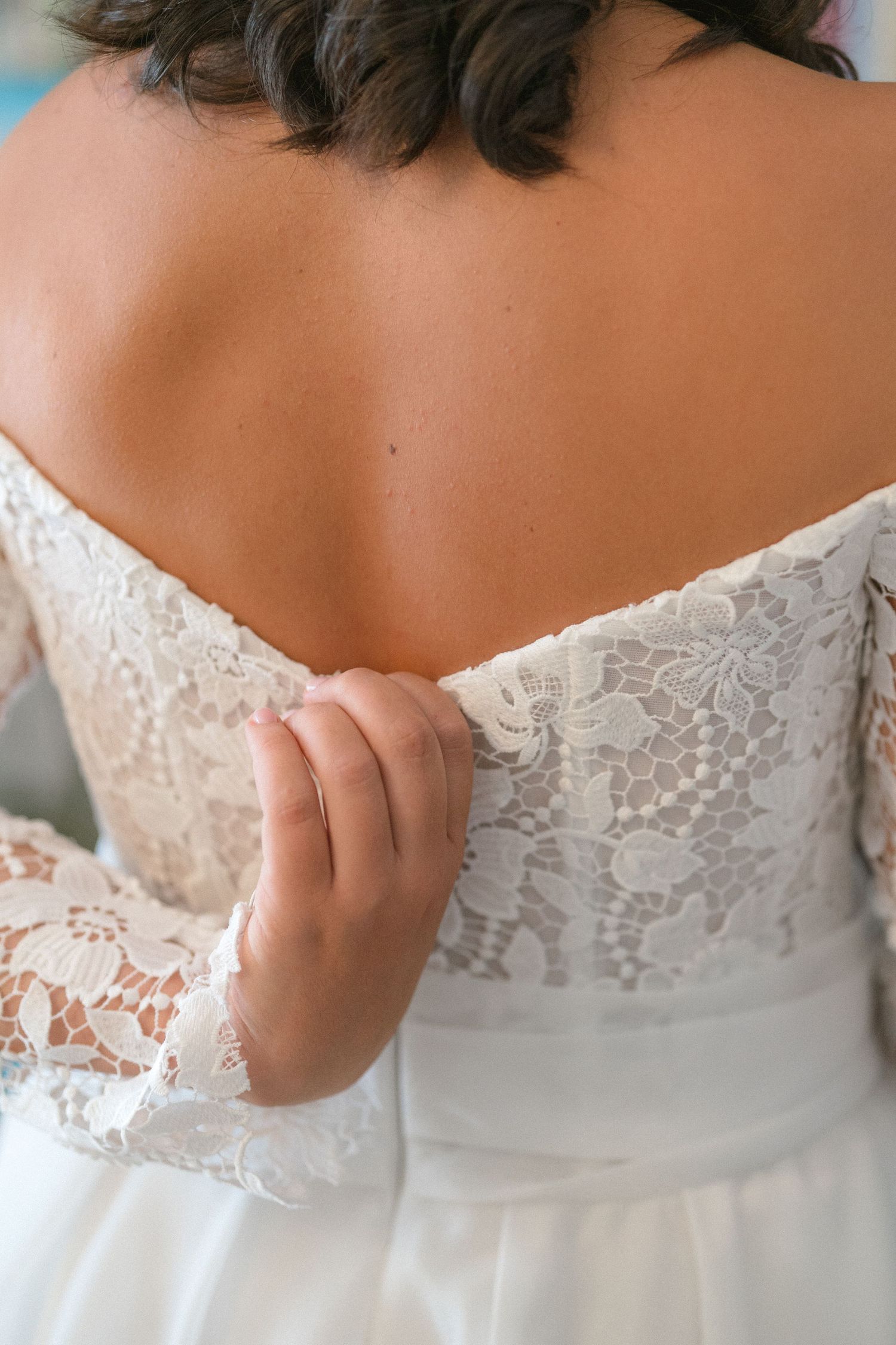 Close-up details of delicate white lace trim on a wedding dress bodice.