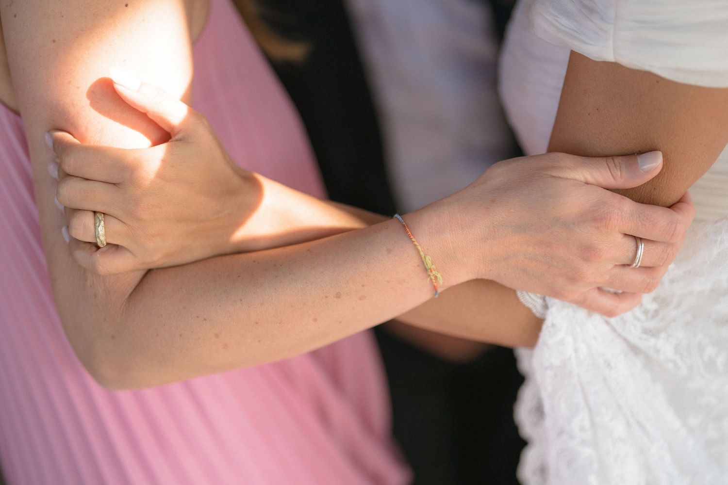 Series of closeup detail shots showing wedding rings and hands at an intimate ceremony.