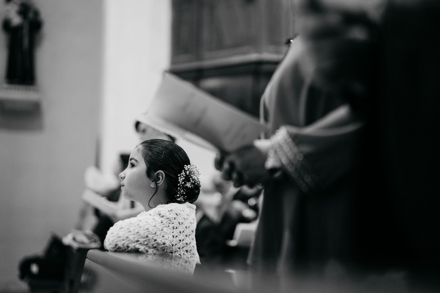 Elegant bride in white lace dress with buttons down the back during wedding ceremony.