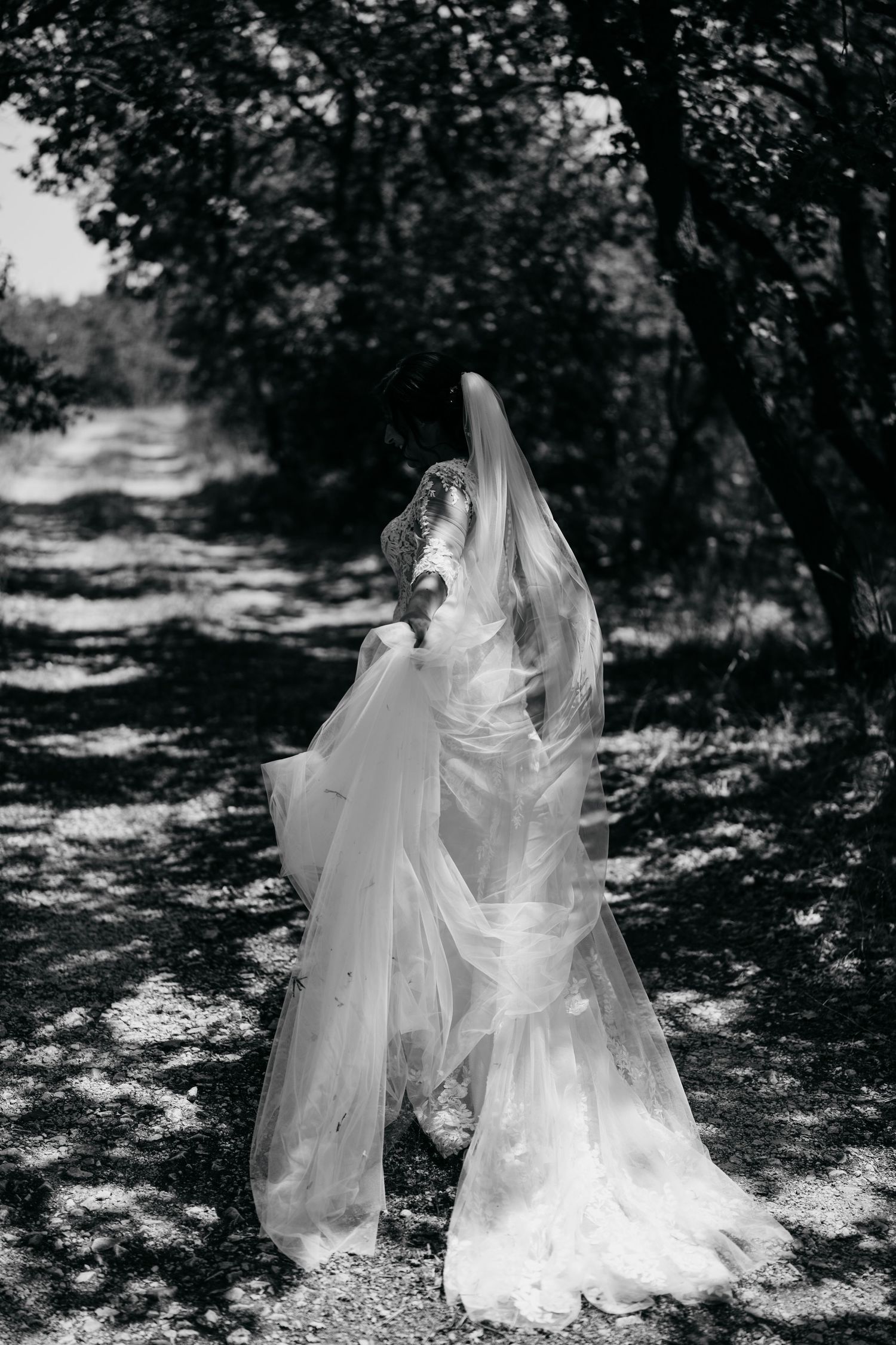 Ethereal white veils flow in an outdoor garden setting creating a dreamy atmosphere.
