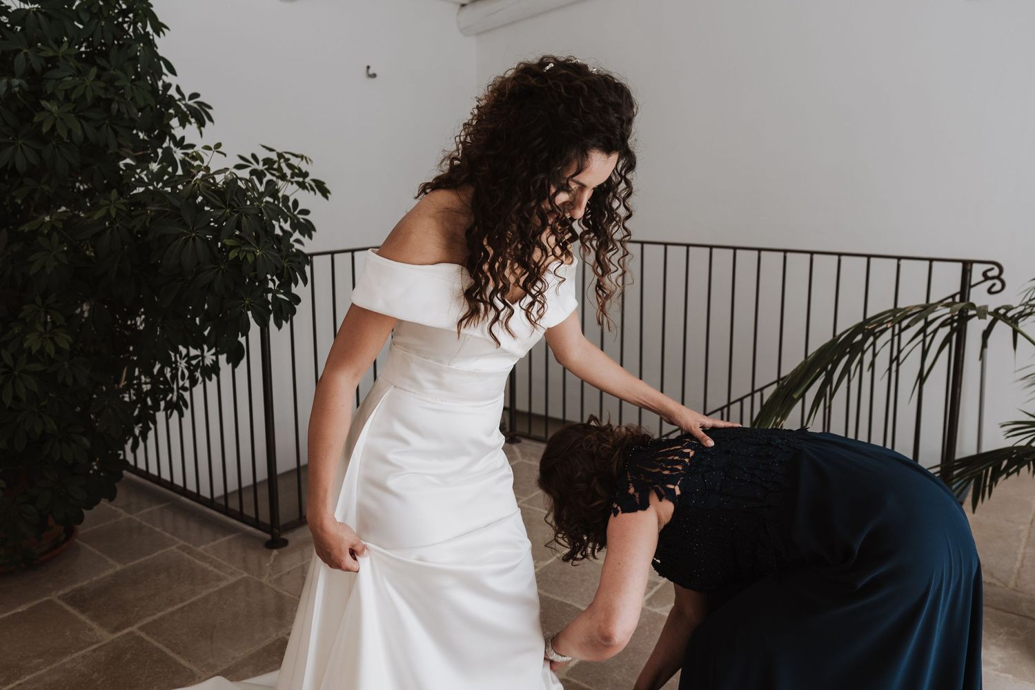 Wedding dress fitting moment captured in candid black and white photography.