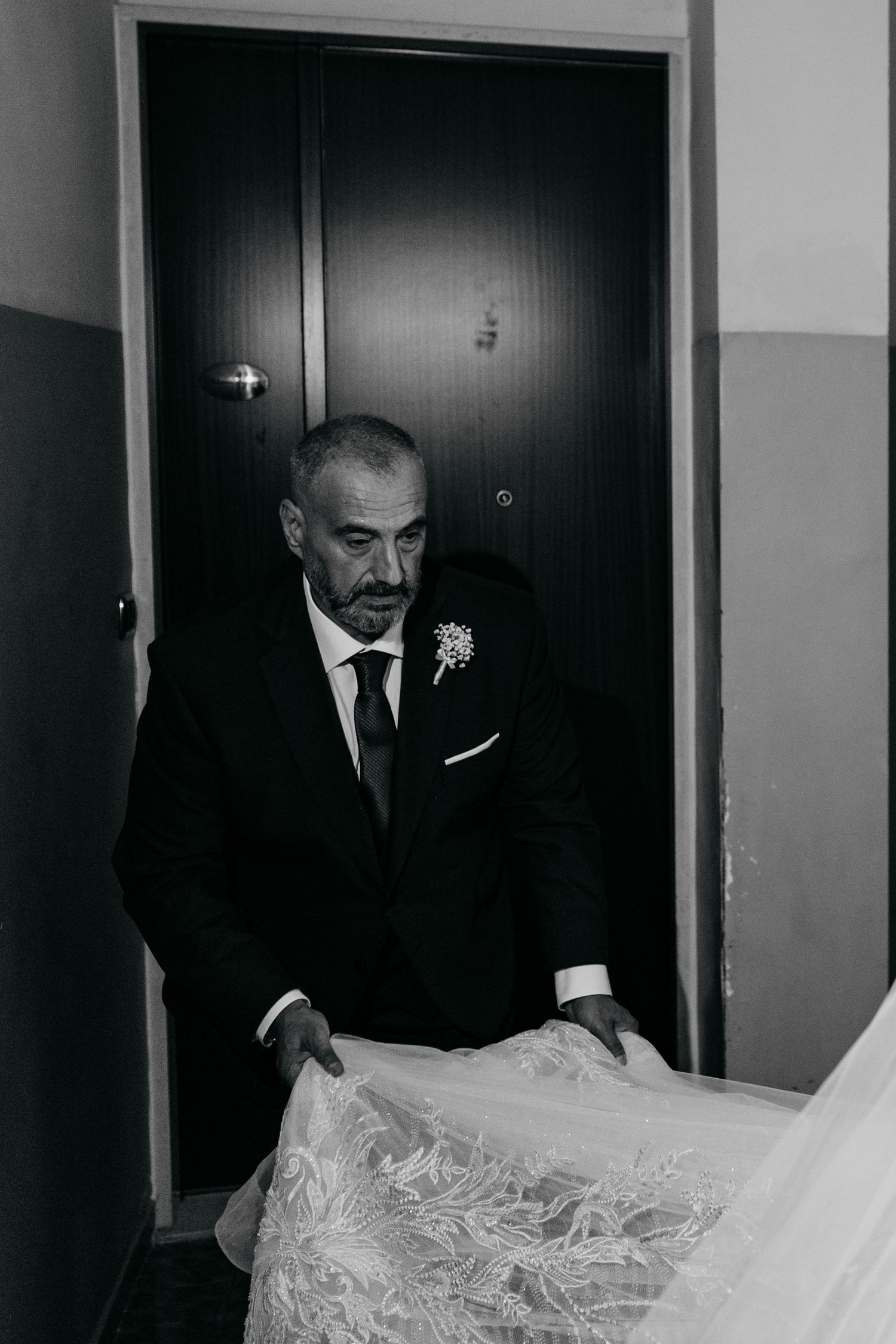 A formal wedding scene in black and white showing preparation moments before the ceremony.