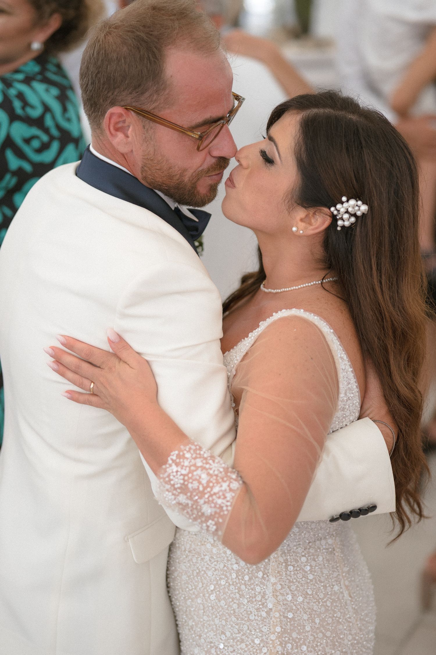 Couple sharing their first dance at wedding reception in elegant attire.