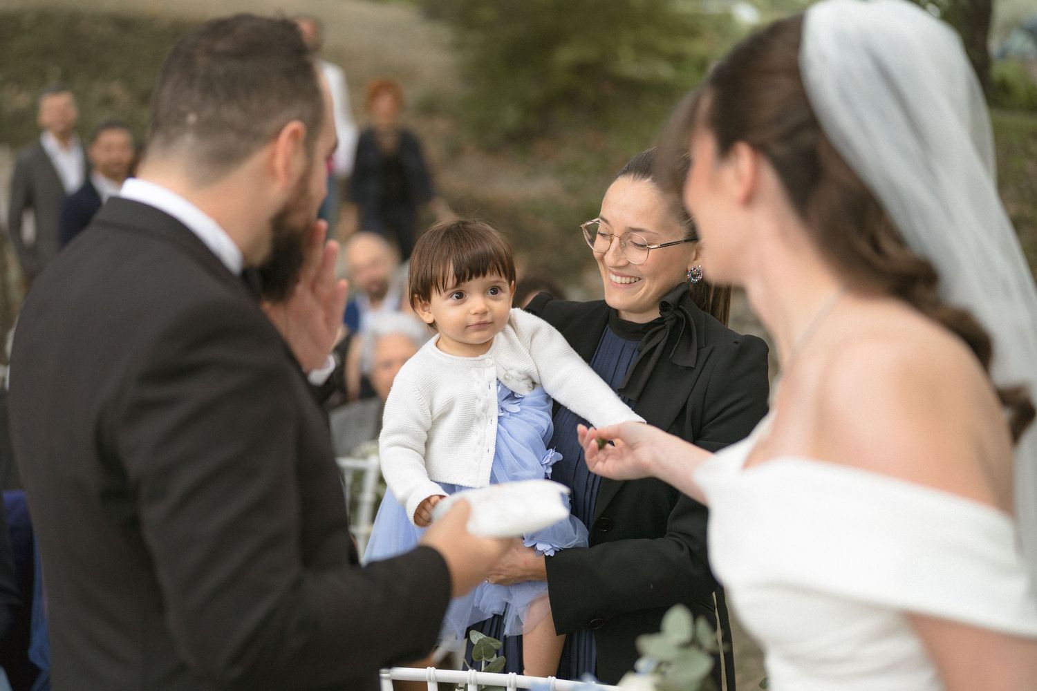 Wedding celebration with guests gathered outdoors during a daytime ceremony.