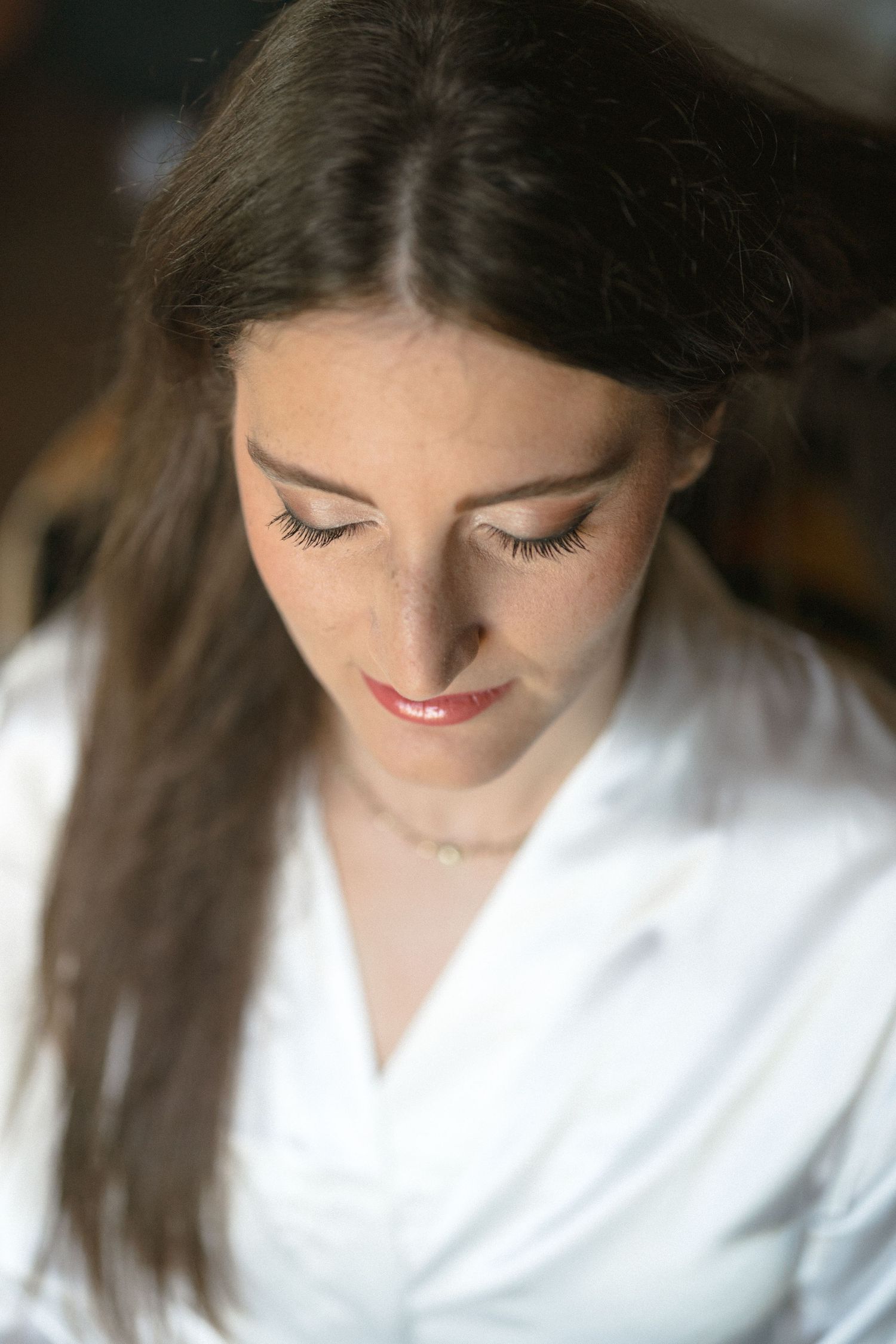 Close-up portrait shots of a bride getting ready with soft makeup and a white robe.