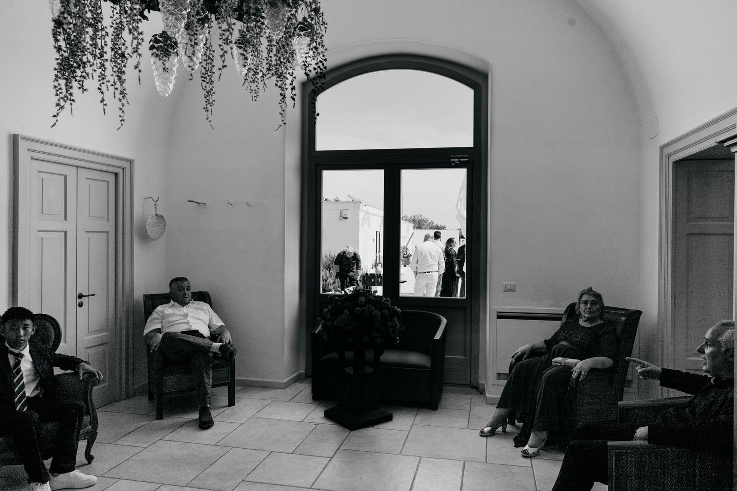 Black and white interior panorama showing multiple doorways and arched ceilings in an empty room.