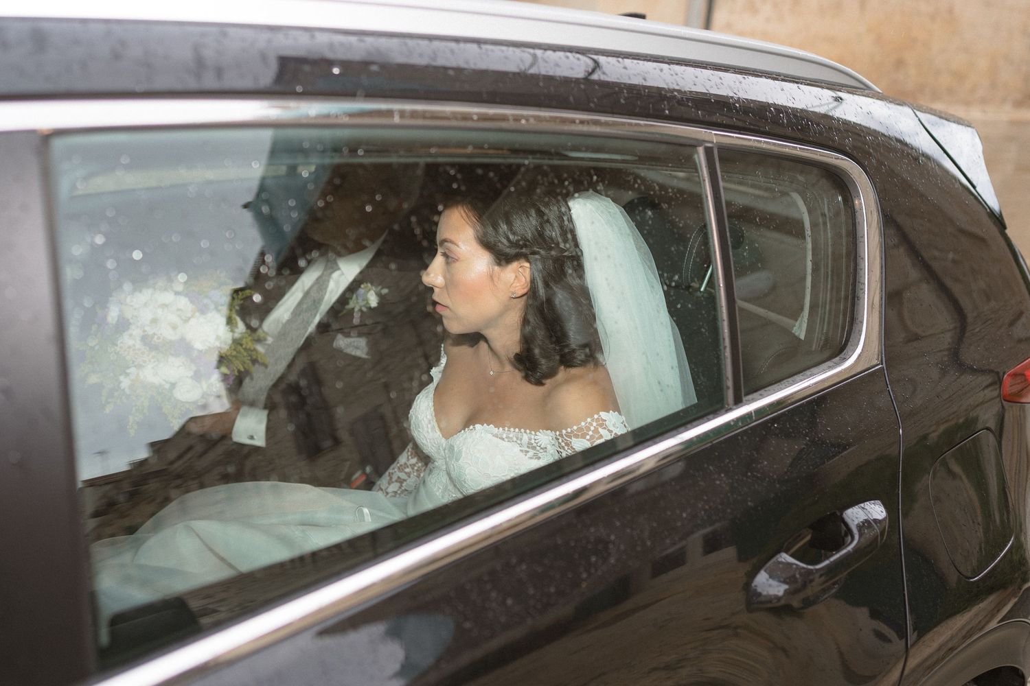 Wedding couple sitting in car after ceremony.