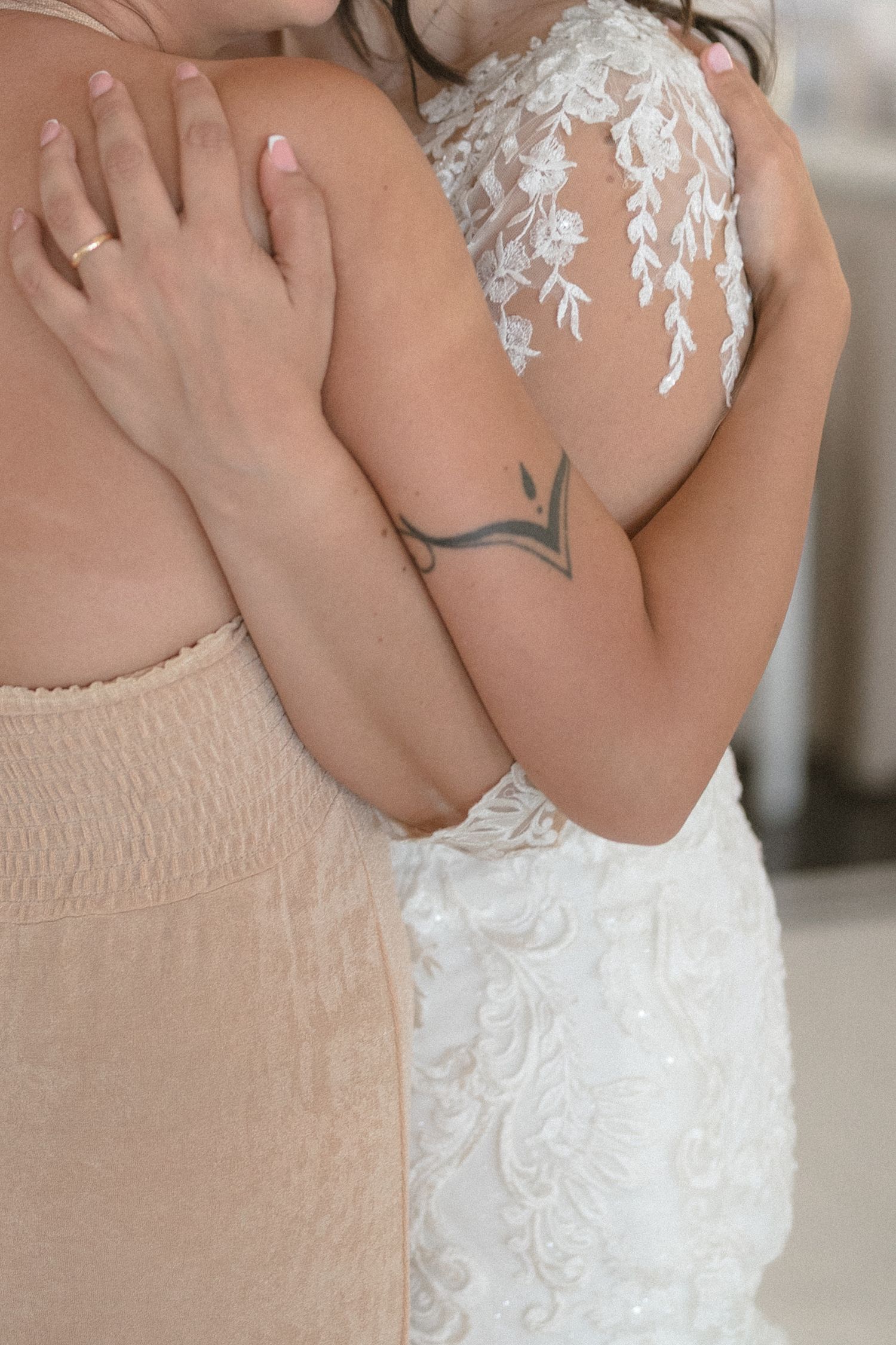 Close-up detail of delicate lace and beading on a white wedding dress bodice.