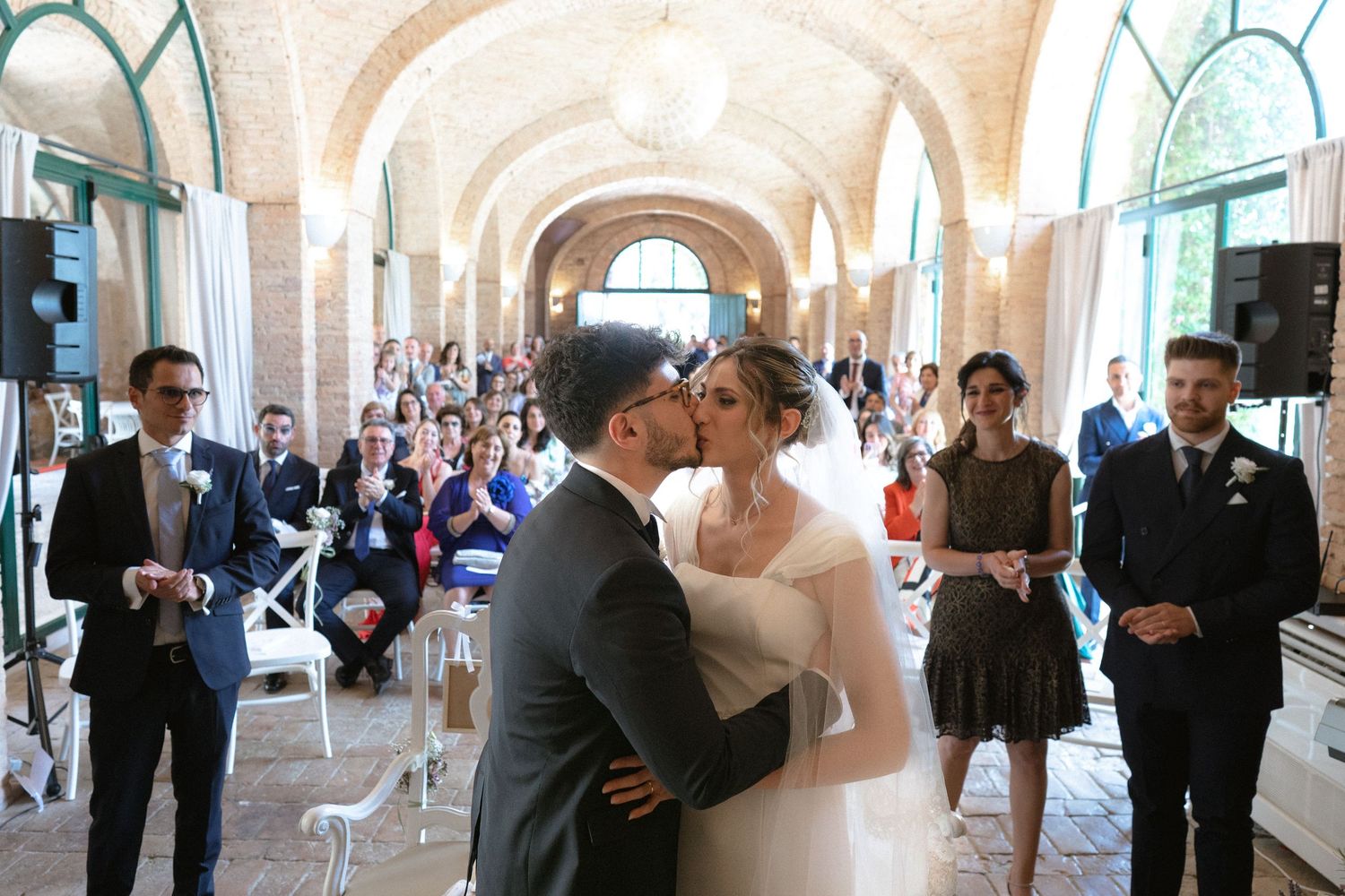 Romantic wedding moments unfold under a series of elegant white archways.