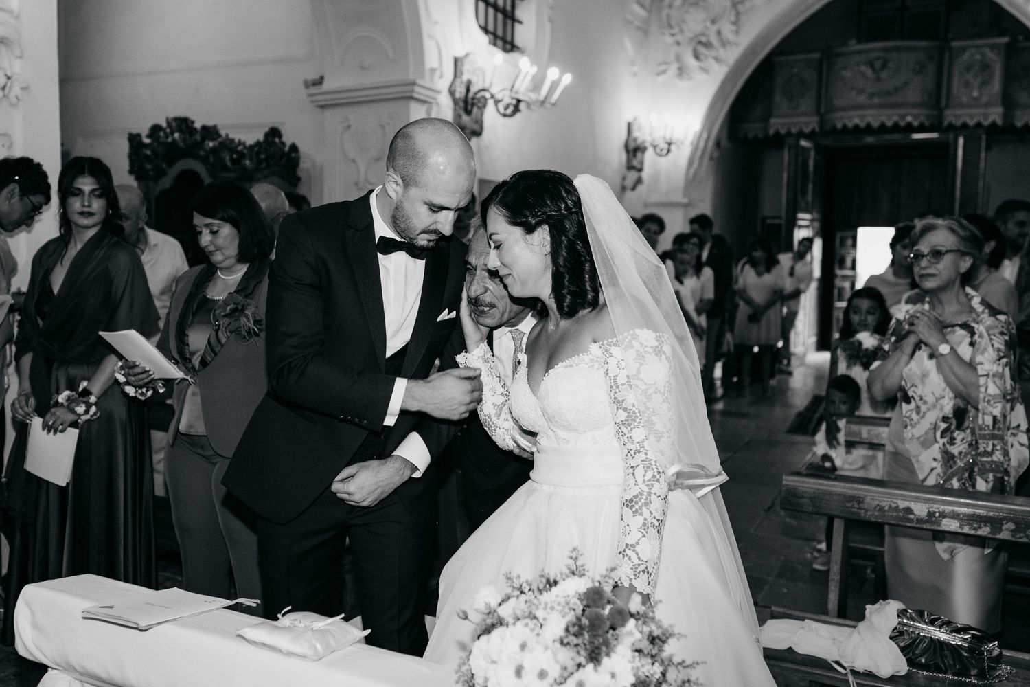Black and white wedding photos showing reception moments with guests dancing and celebrating at an indoor venue.