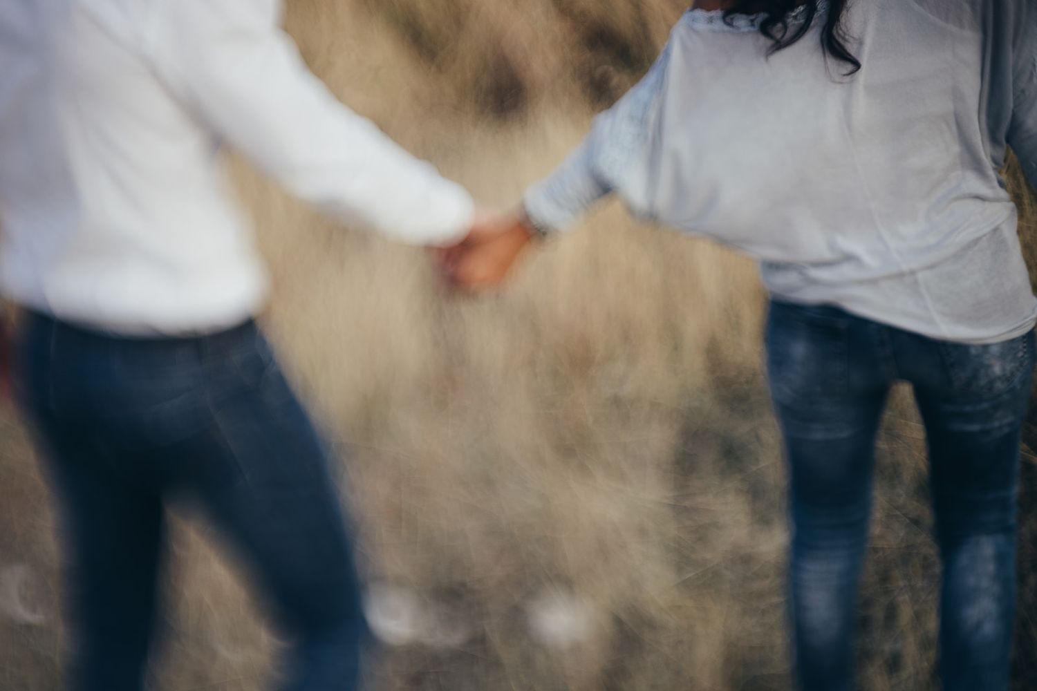 Blurred motion shot of people in casual clothing standing together in a dusty or smoky environment.