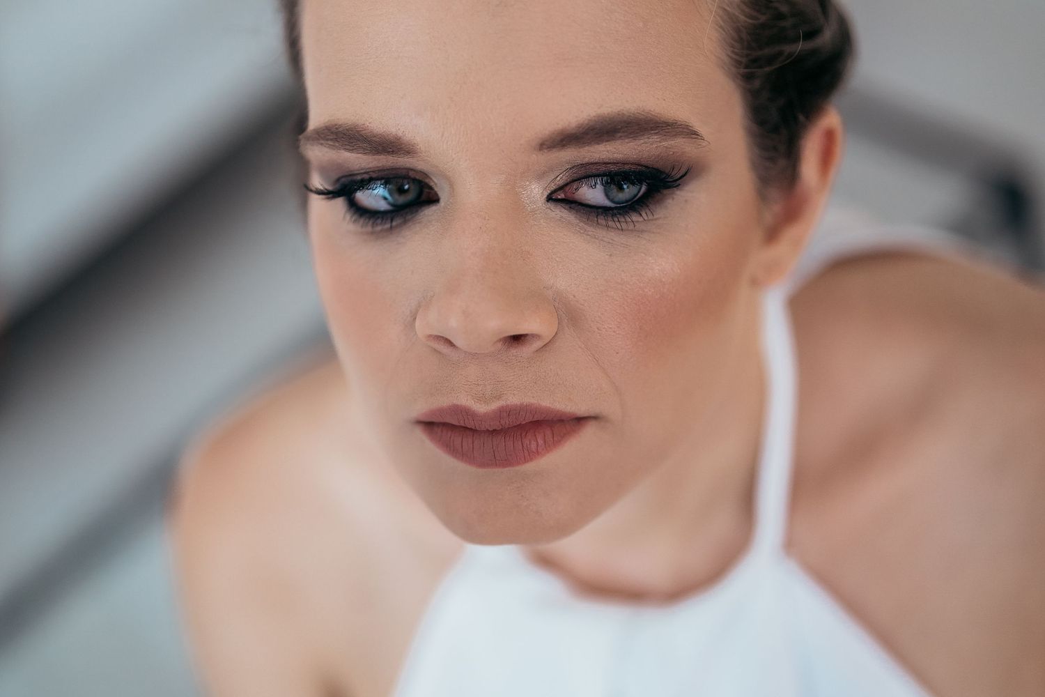 Close-up beauty shot showing dramatic eye makeup and mauve lipstick.
