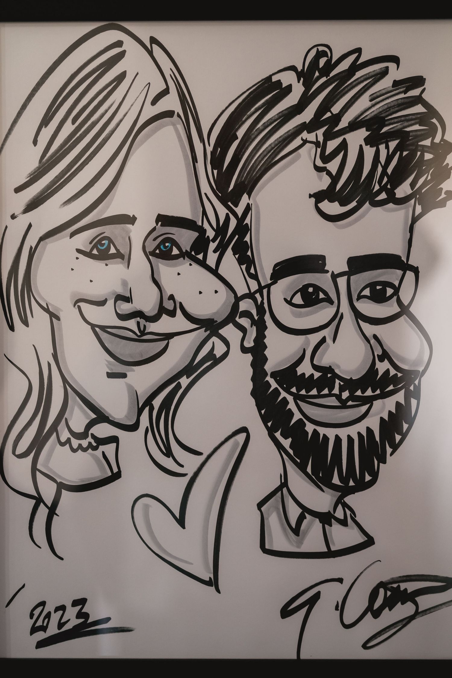 Playful black and white caricature sketch of a smiling couple with heart detail.