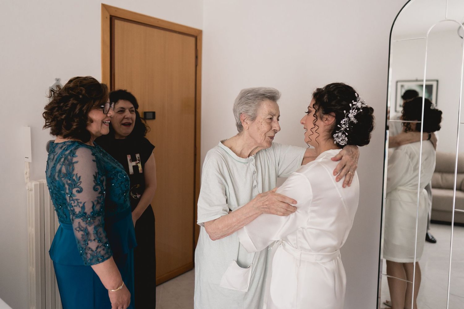 A touching pre-wedding moment with family members in formal attire.