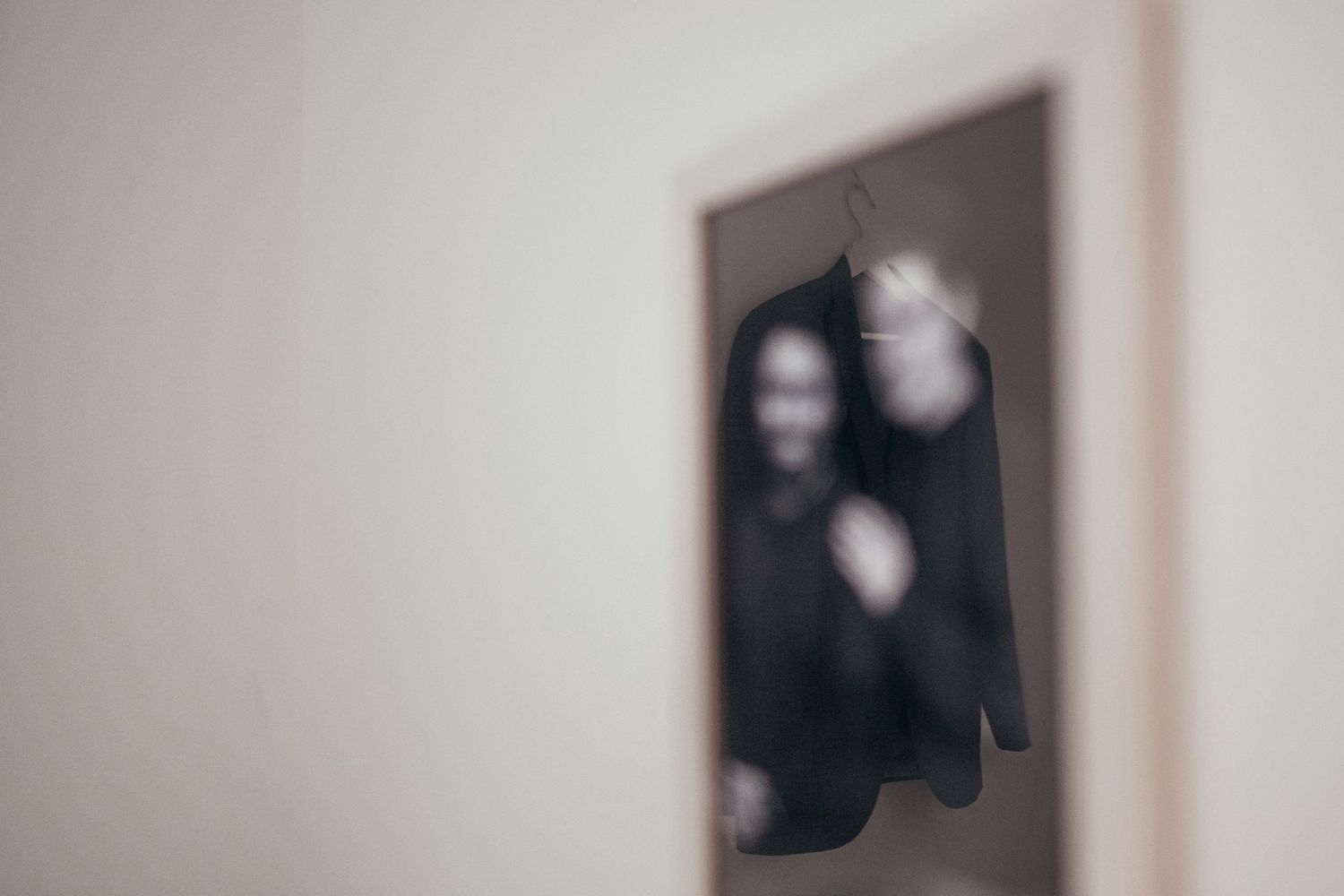 Blurred artistic photograph of a framed image on a wall.