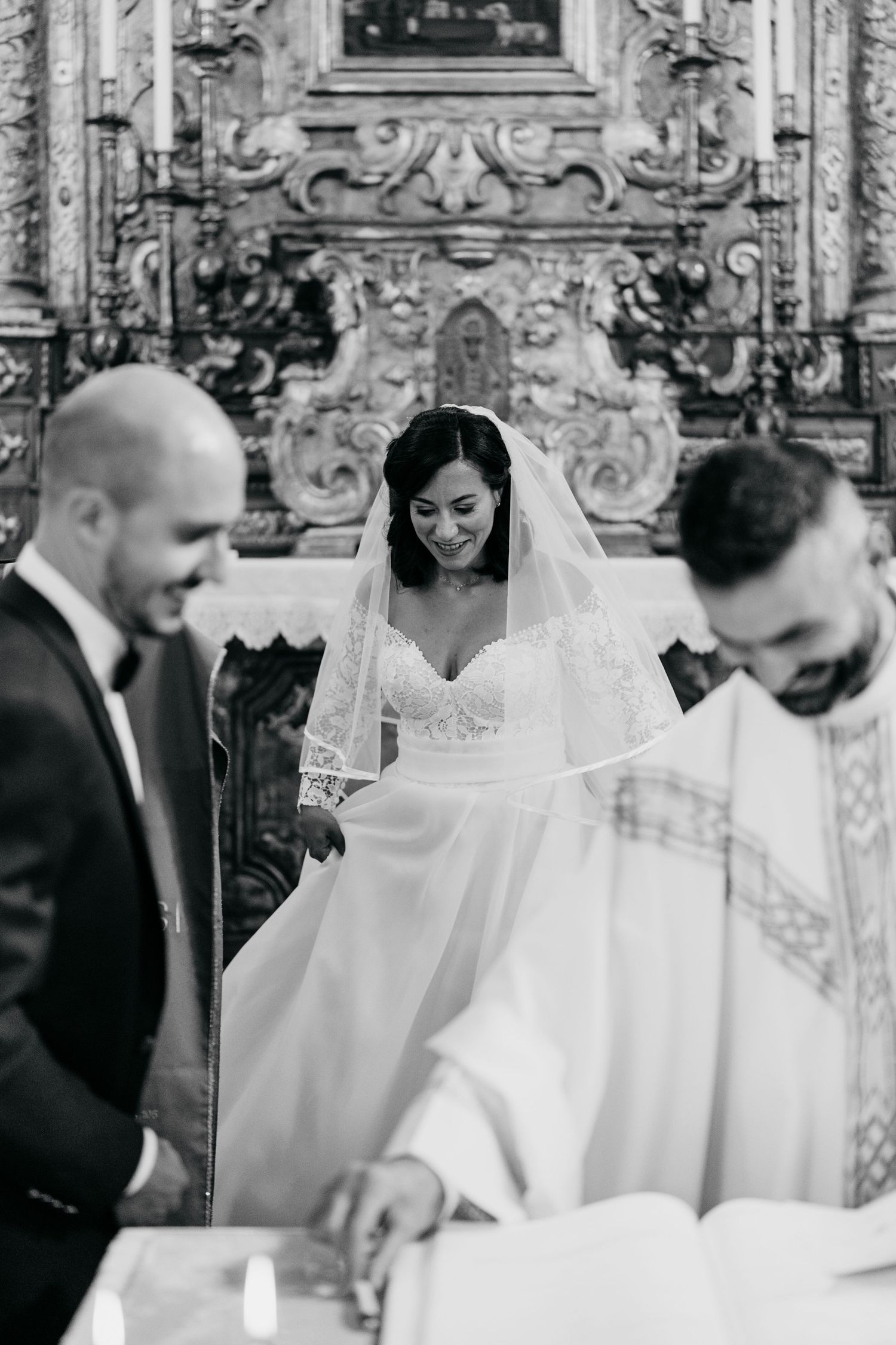 A traditional church wedding ceremony takes place in an ornate sanctuary with decorative baroque details.