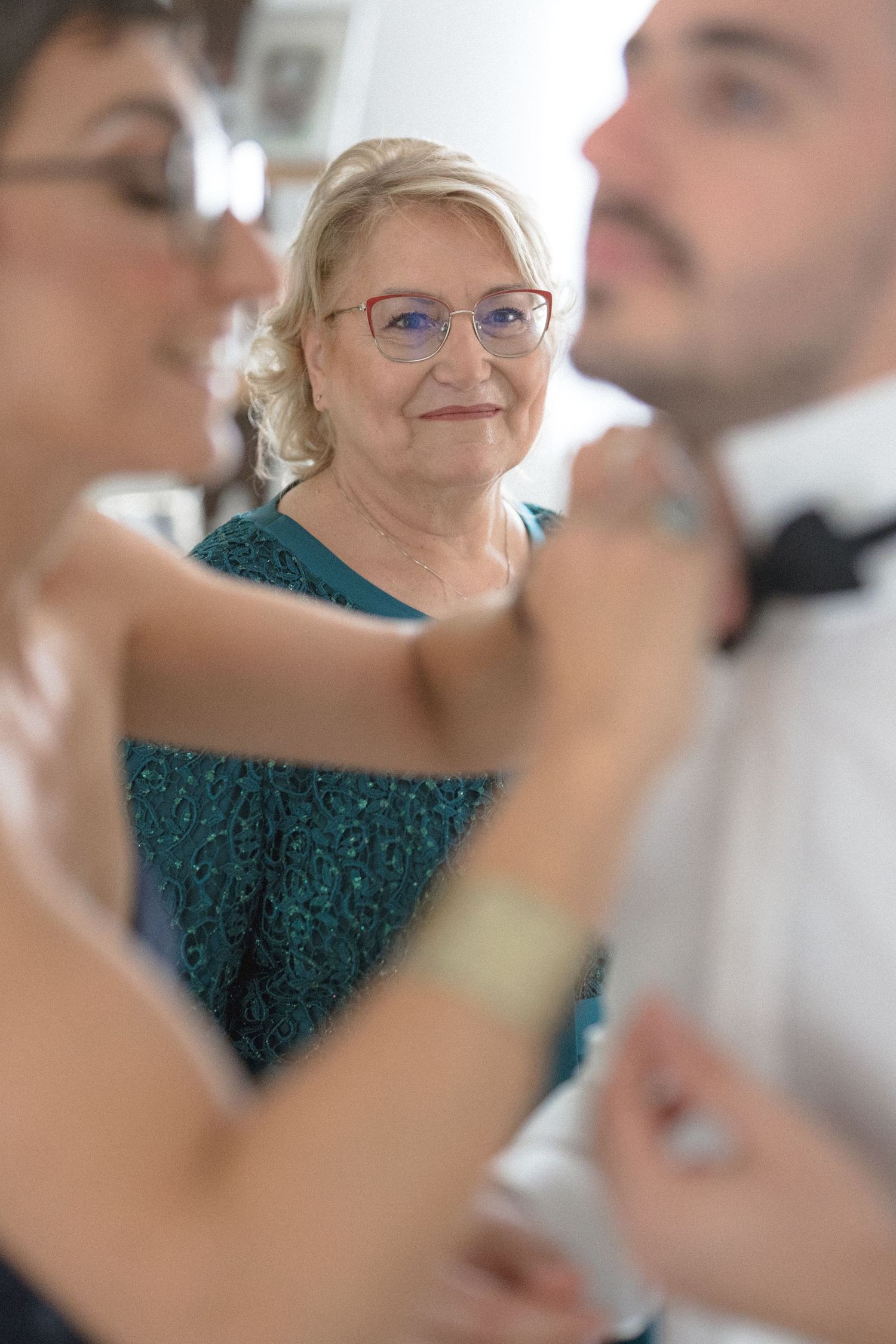 Wedding preparations in progress with attendees in a teal dress and formal attire getting ready for the ceremony.