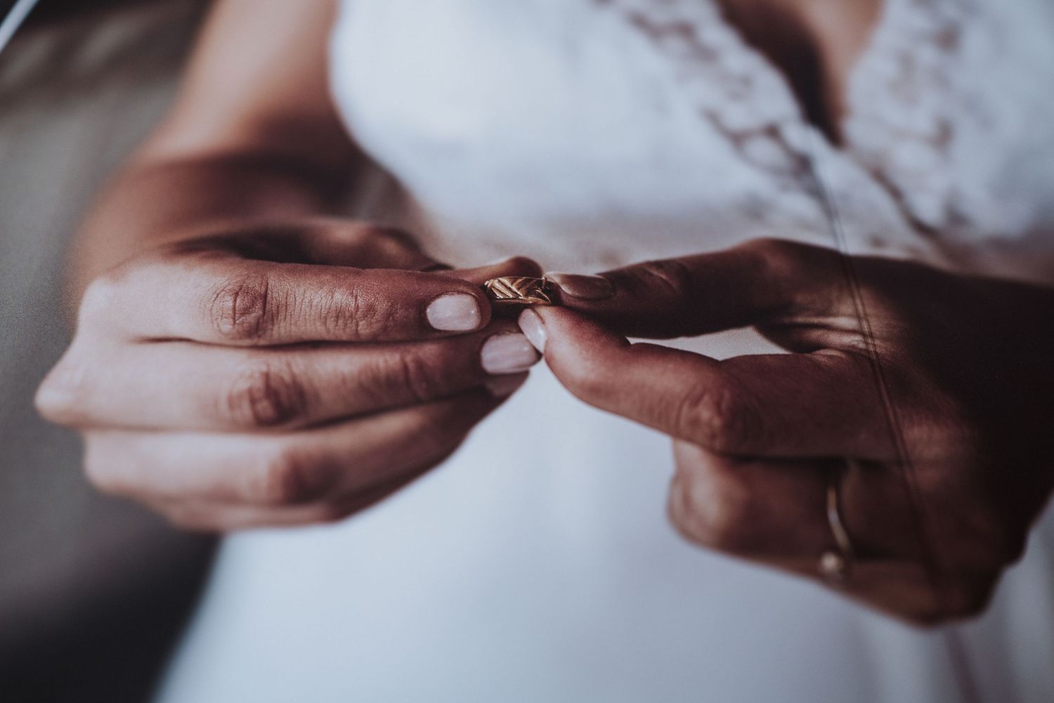 Close-up shot of hands exchanging a wedding ring during a ceremony.