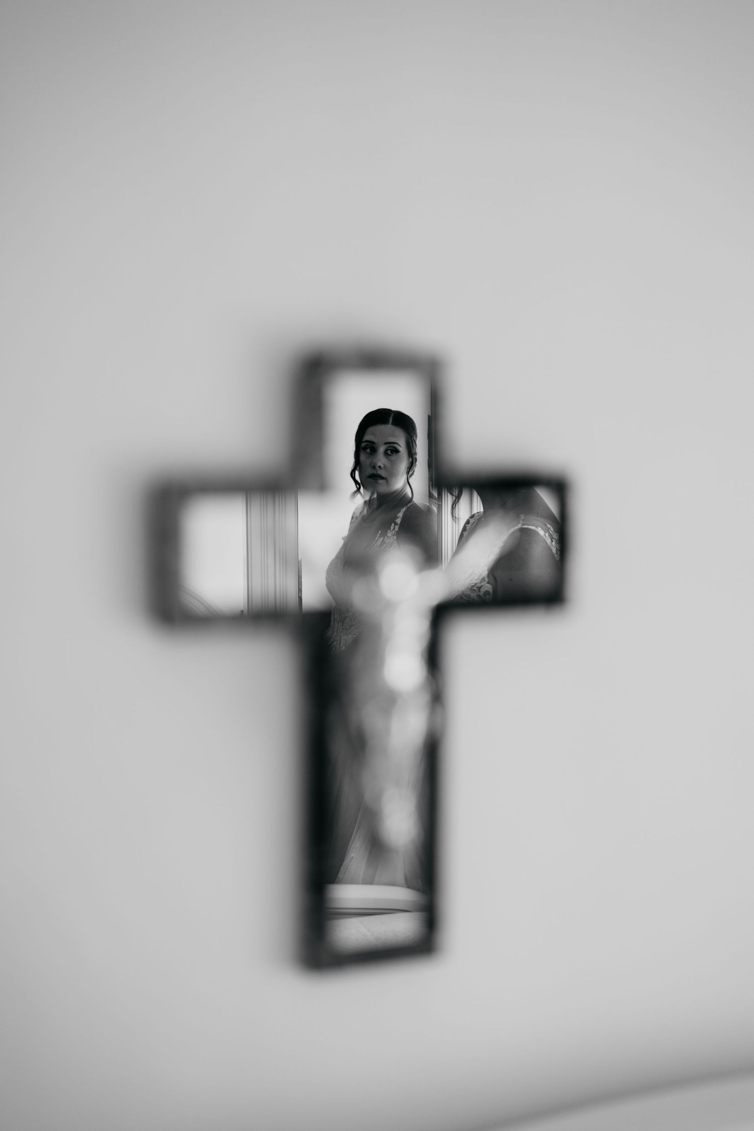 A creative silhouette photograph framed within a cross-shaped window or frame.