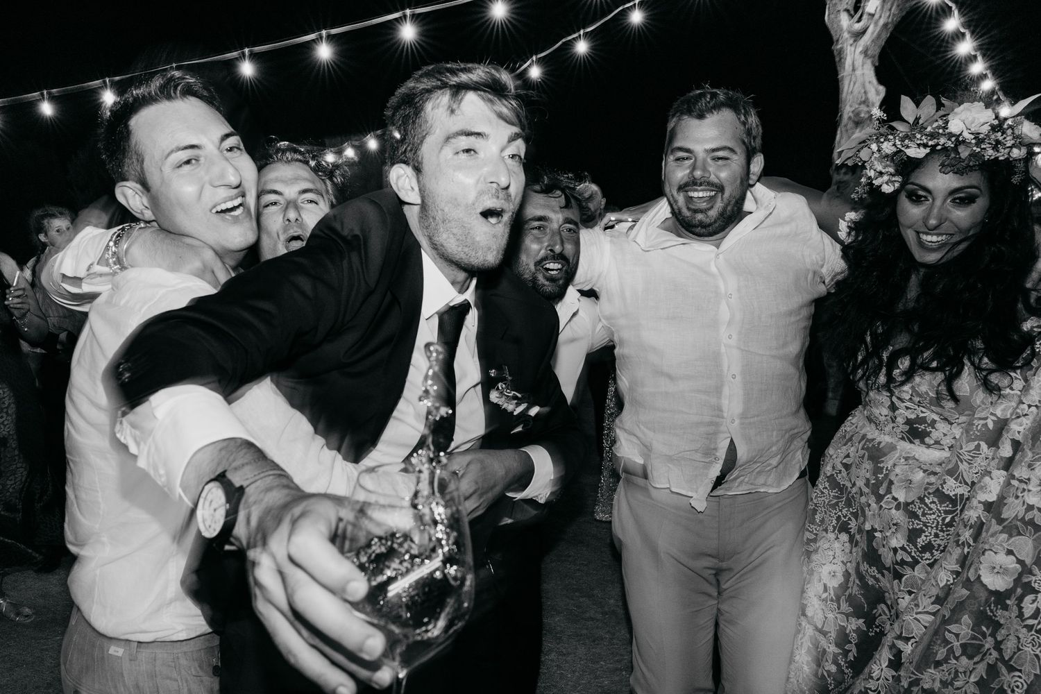 A collection of black and white party photos showing people laughing and celebrating together at a festive gathering.