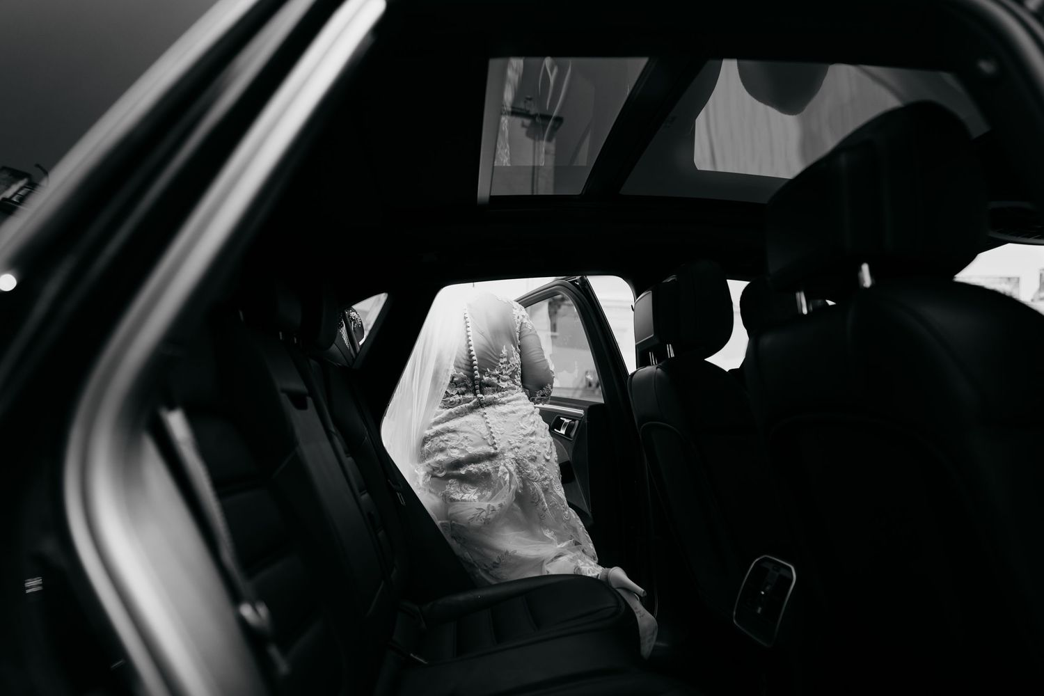 Dark interior of a car captured in dramatic black and white photography.