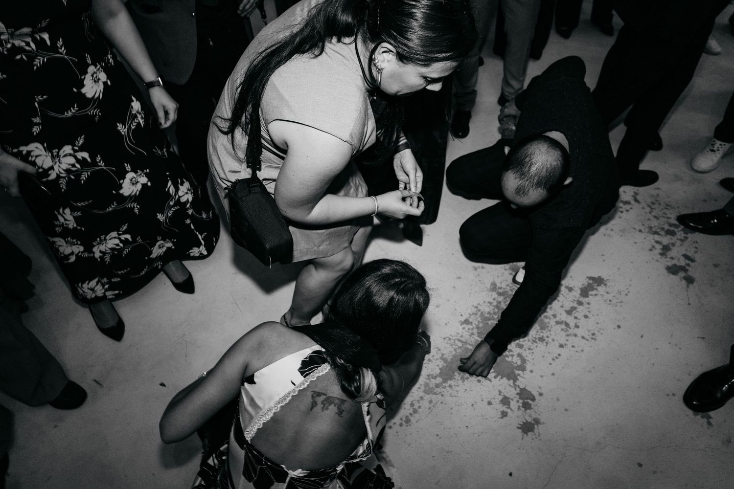 A black and white photo of people dancing and interacting at a lively party or event.