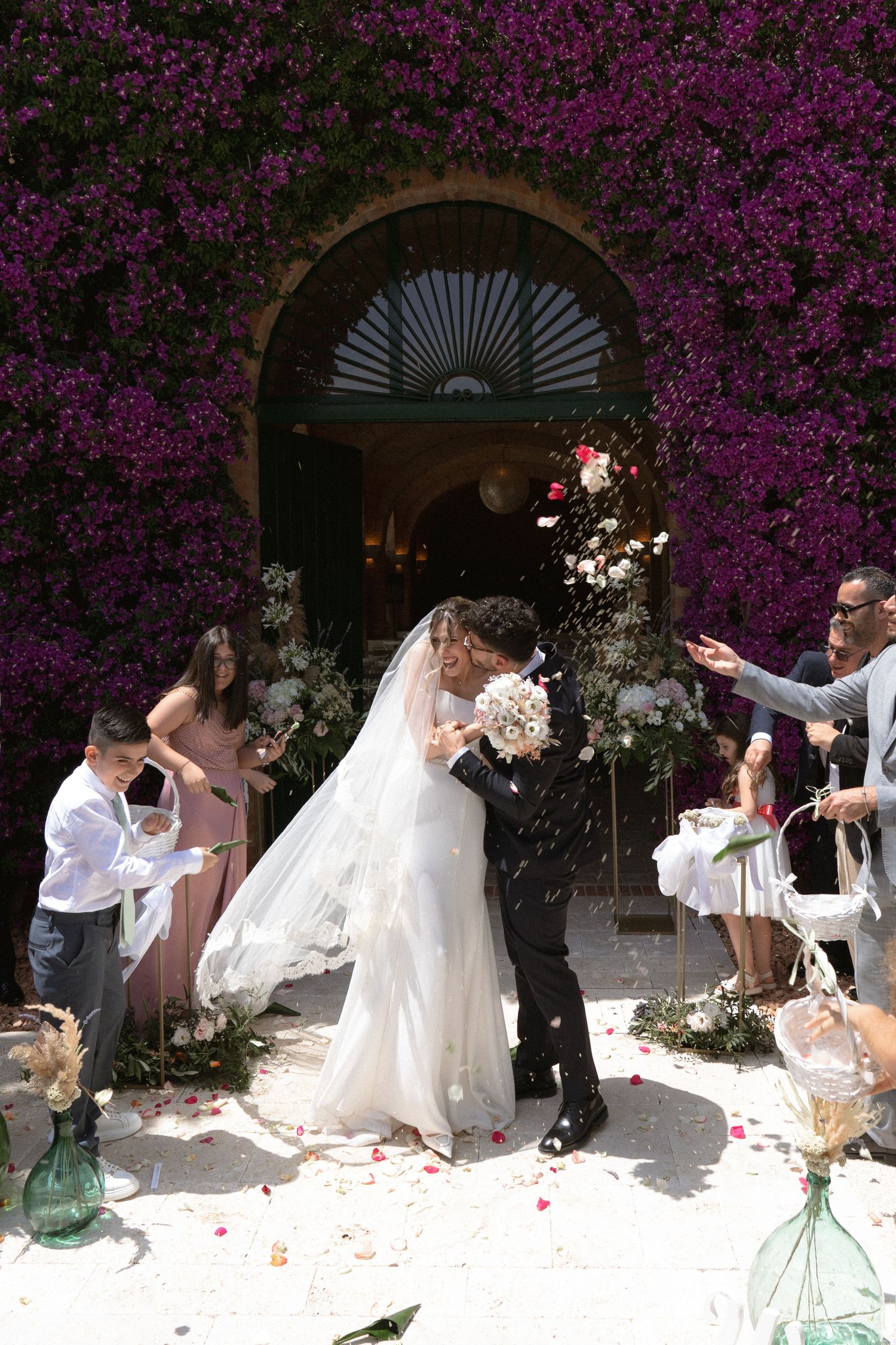 Wedding celebration sequence with flower petals against purple flowering backdrop.