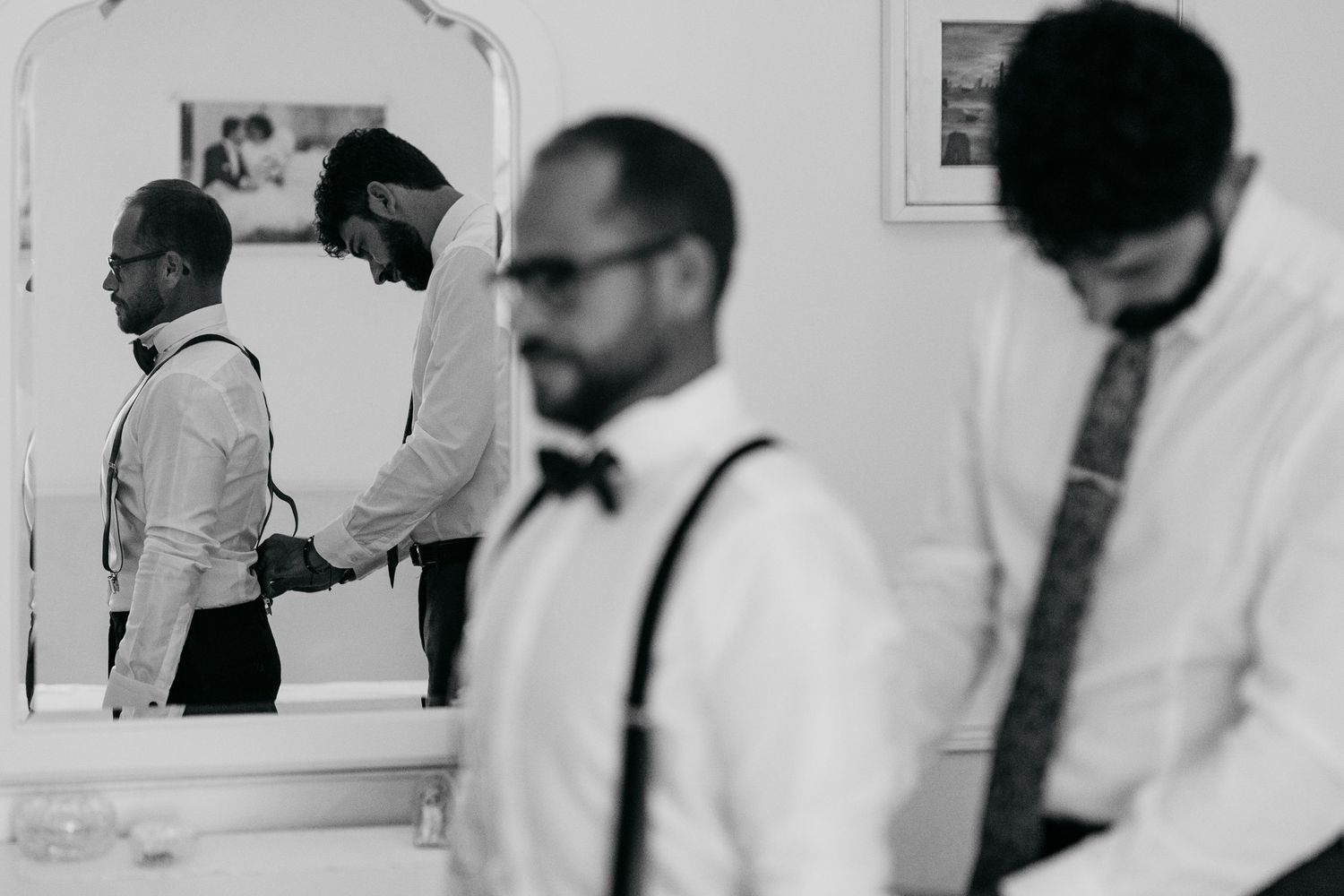 Black and white photo showing medical professionals examining documents and x-rays in a clinical setting.