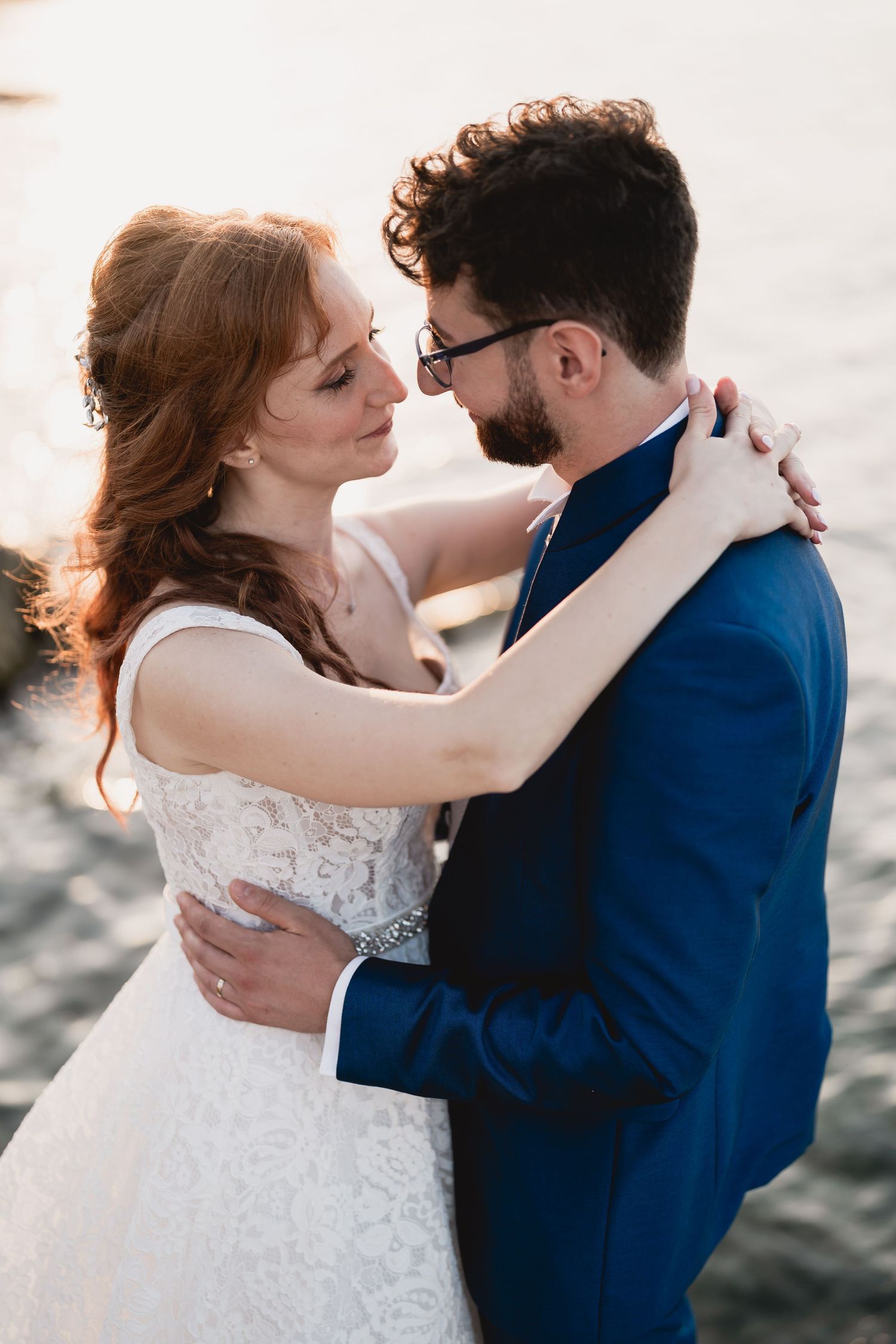 Romantic wedding portrait of a couple embracing by the ocean.