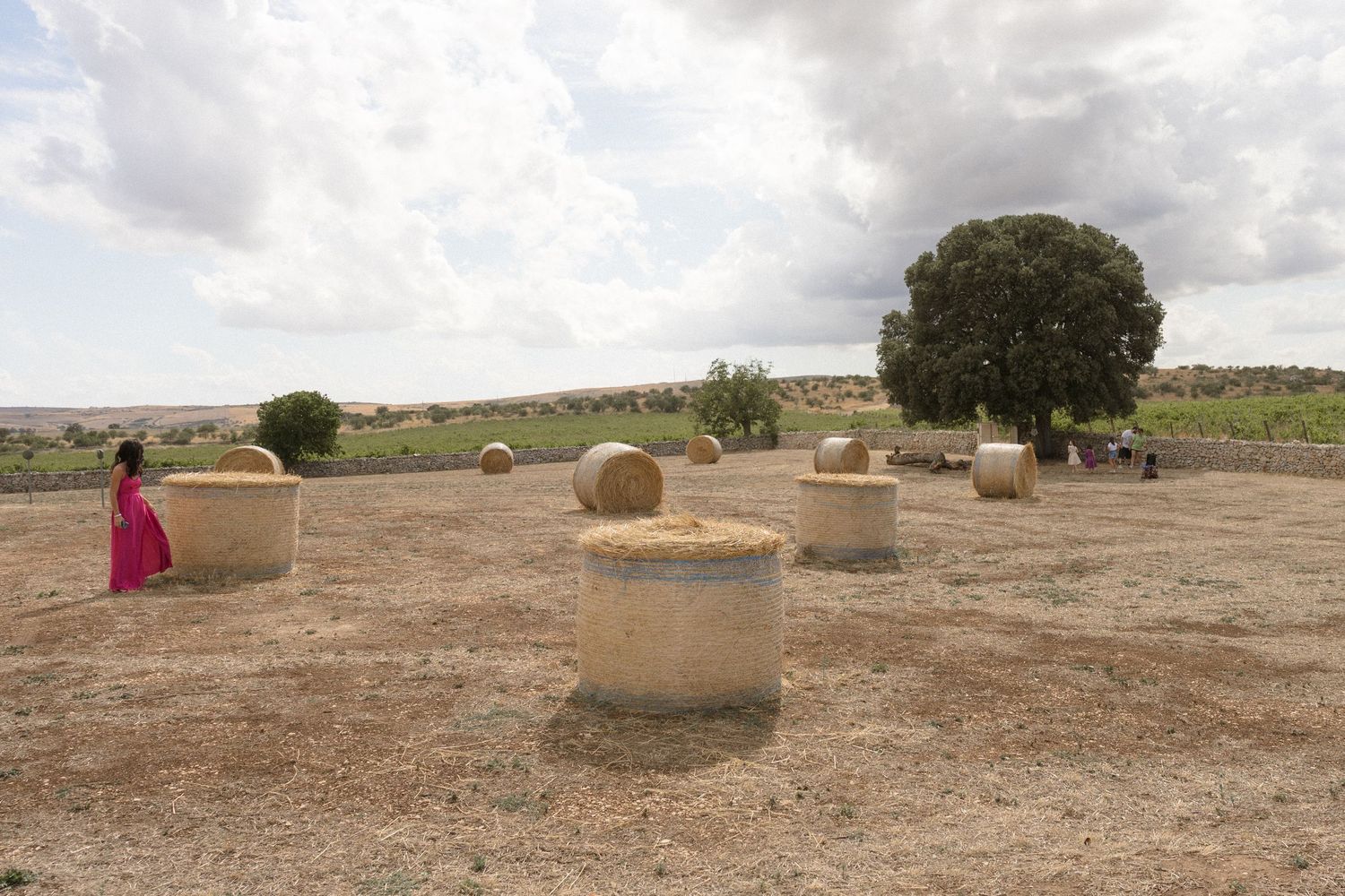 Desert landscape with scattered adobe structures under cloudy sky.