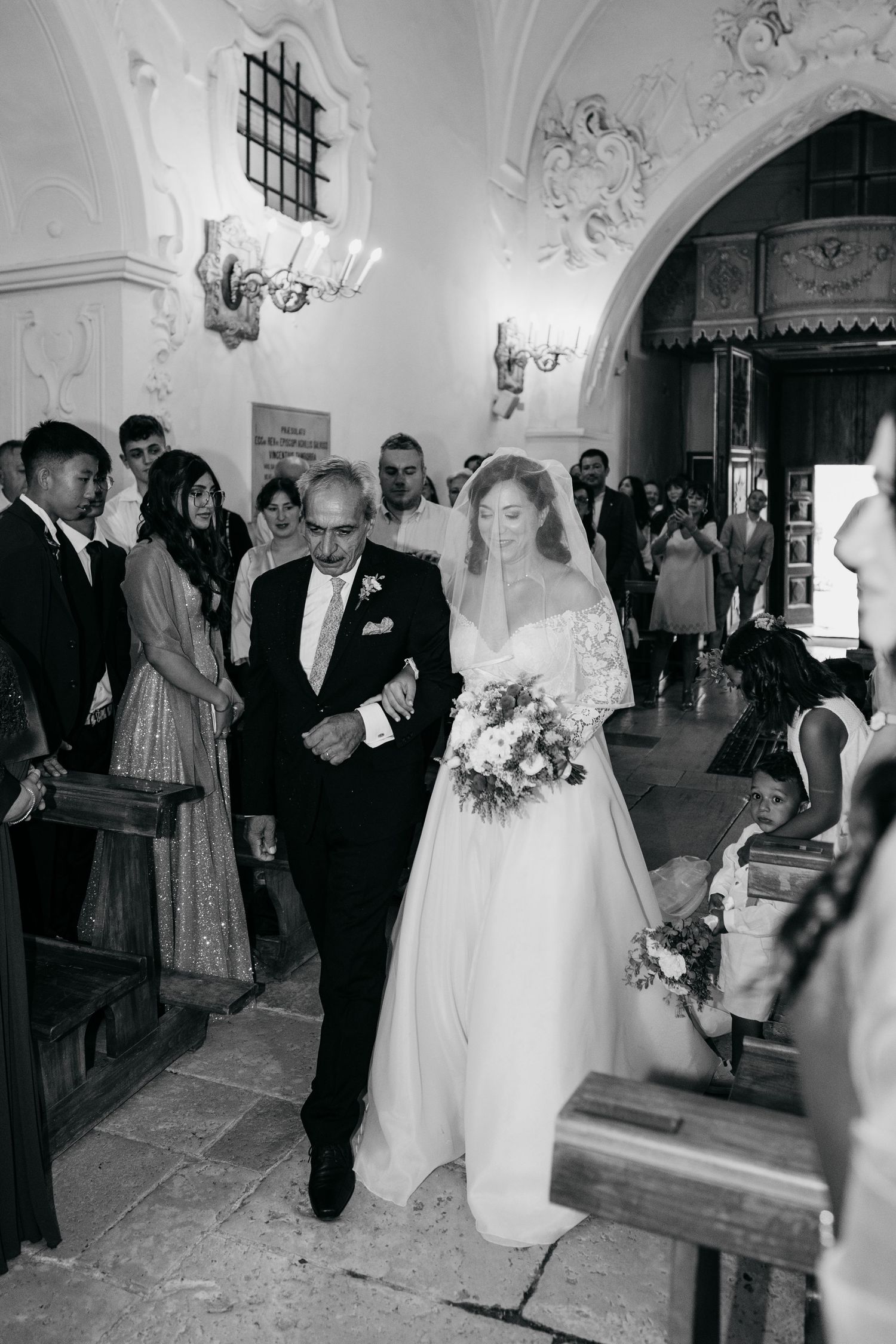 Black and white wedding ceremony photos showing bride and guests in an ornate church interior.
