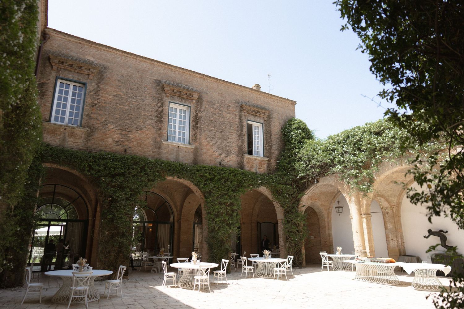 Historic stone building exterior with arched walkways and Mediterranean architectural details.