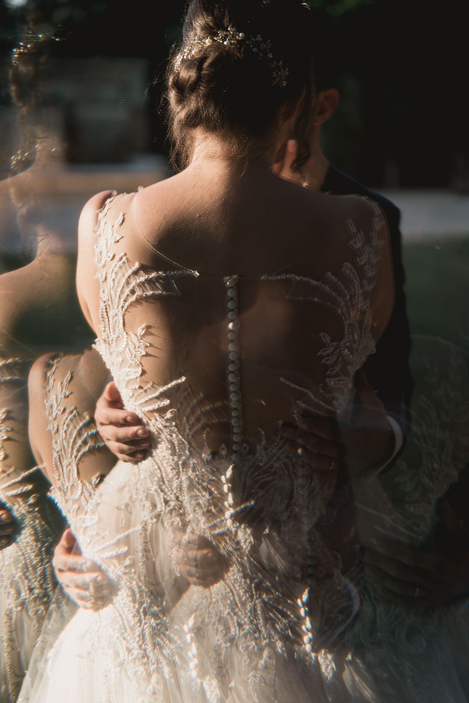 Close-up back view of intricate lace details and buttons on a wedding dress.
