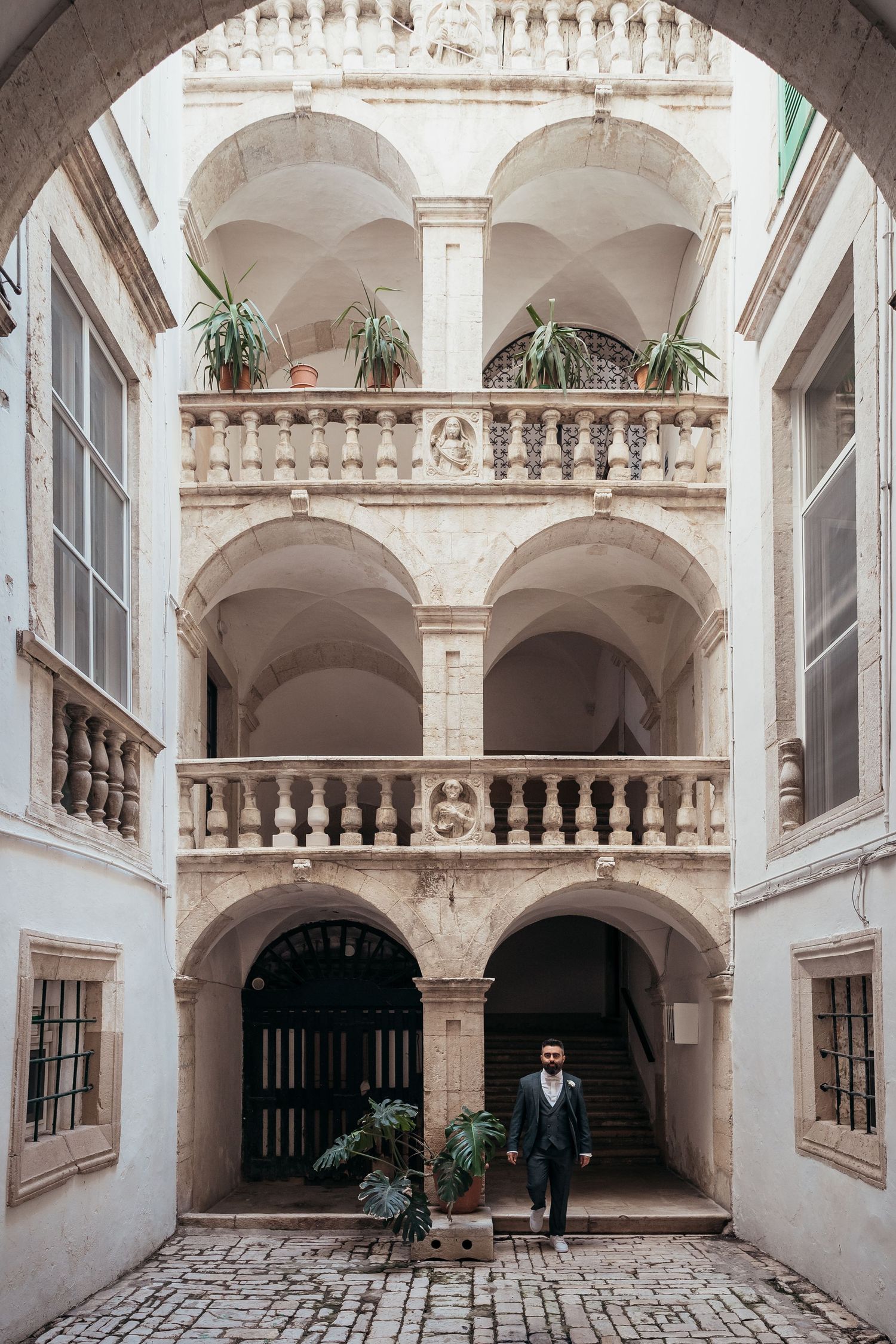 A beautiful ornate courtyard with white stone arches and balconies in a historic building.