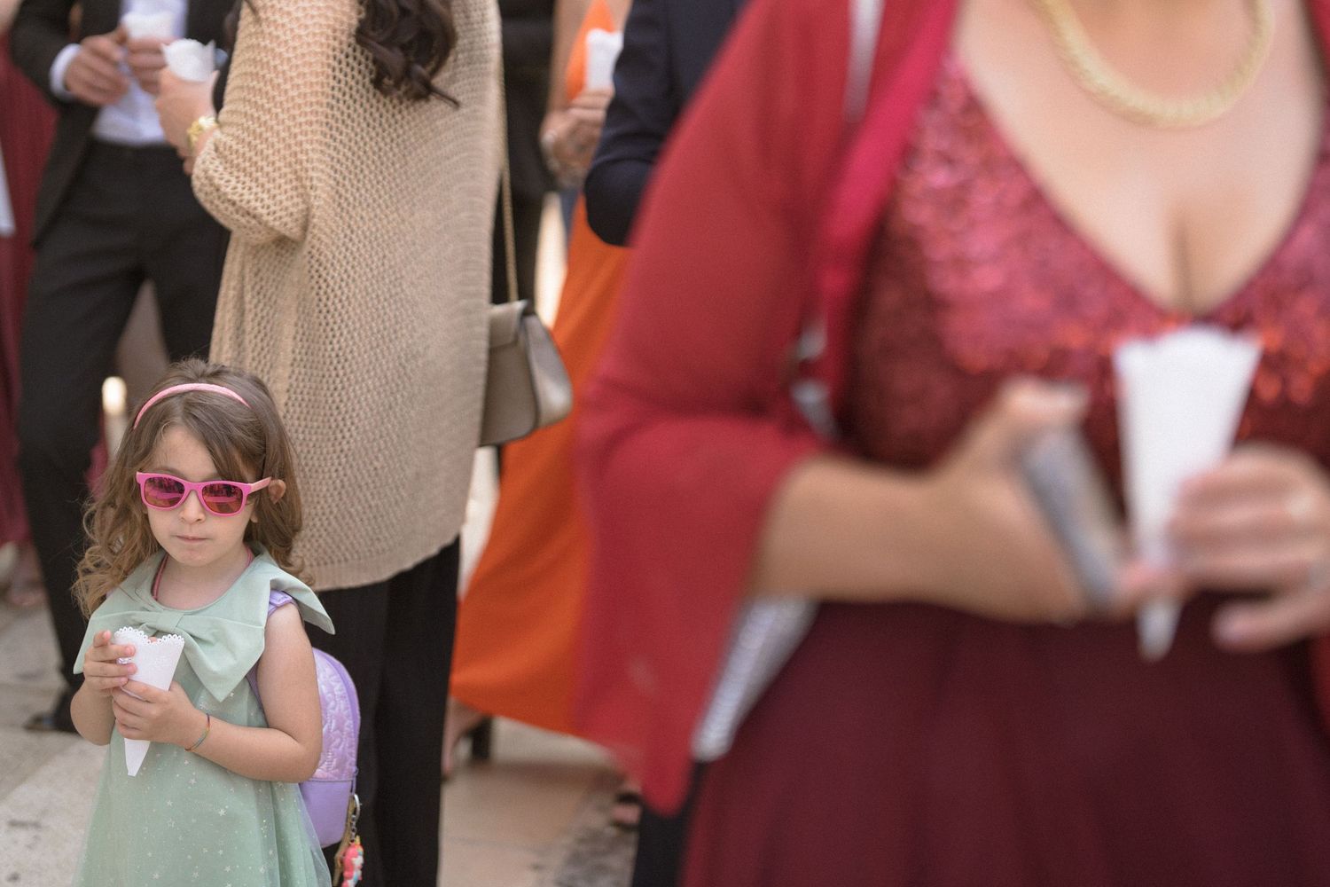 Wedding reception guests mingling and celebrating in casual attire with burgundy and orange color scheme.