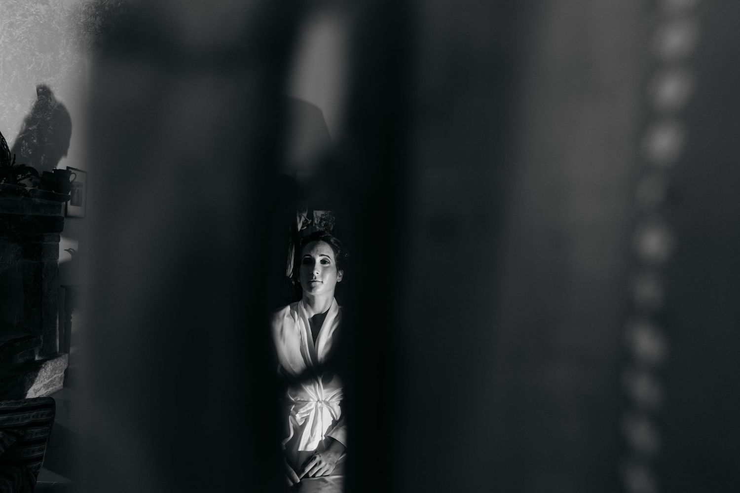 Artistic black and white silhouette of bride through doorway.